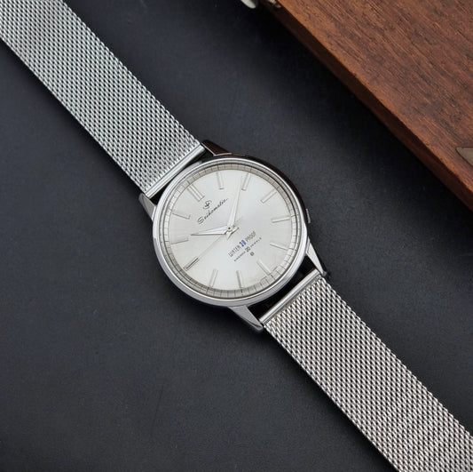 Vintage Seiko Wristwatch Seikomatic J13044E with mesh strap on a dark background dial