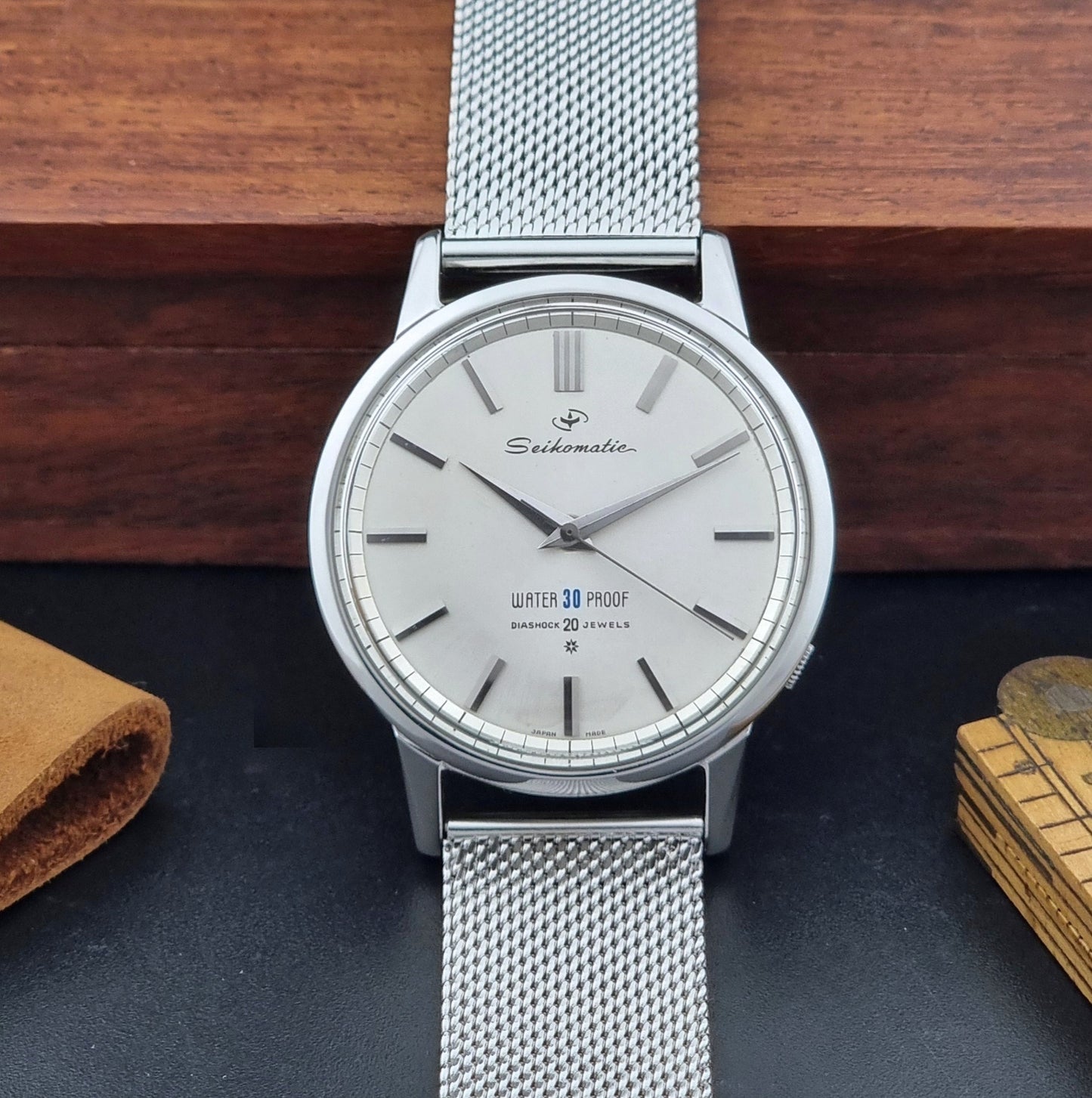 Vintage Seiko Wristwatch Seikomatic J13044E with mesh strap on a dark background dial view