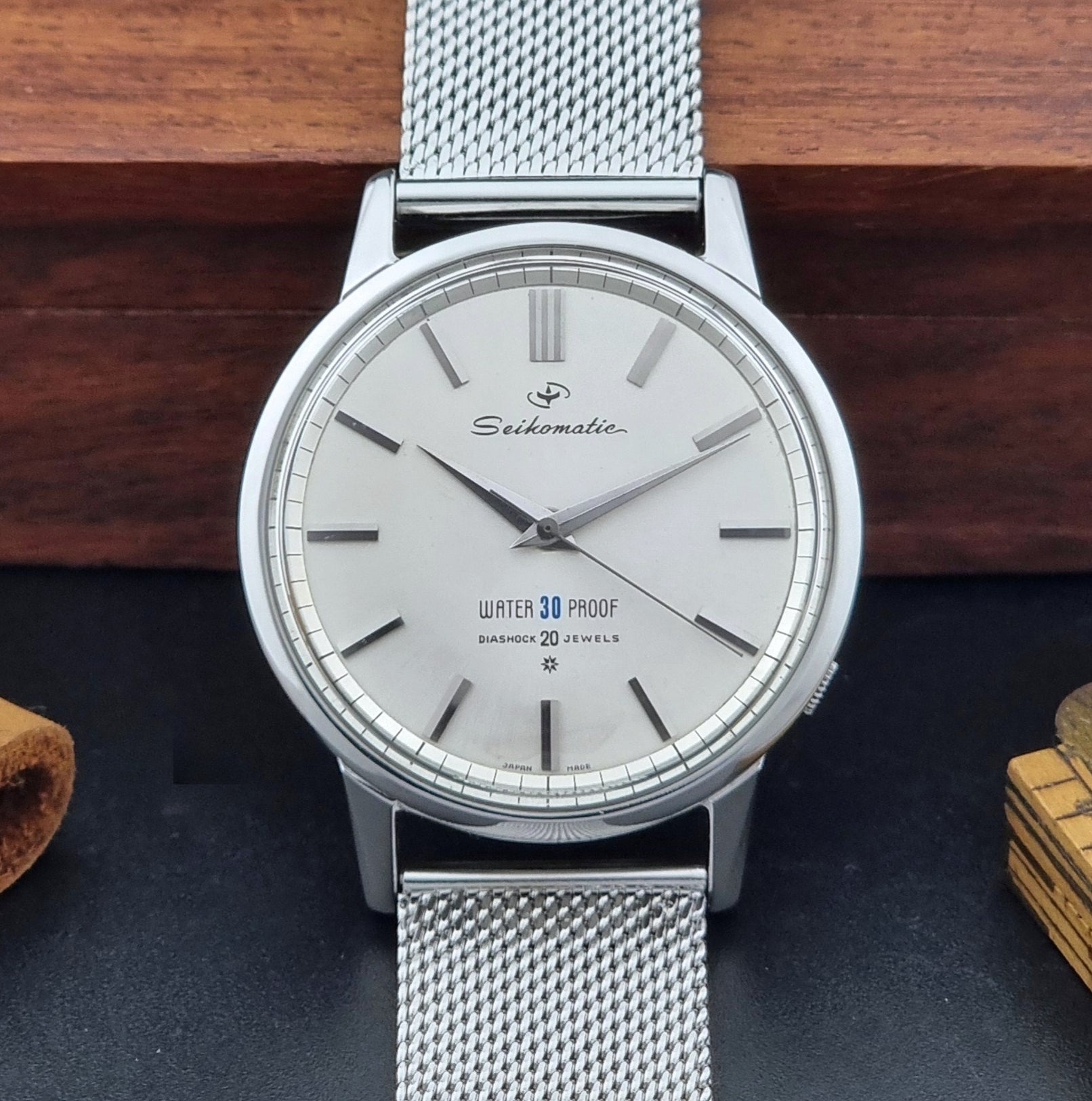 Vintage Seiko Wristwatch Seikomatic J13044E with mesh strap on a dark background front view