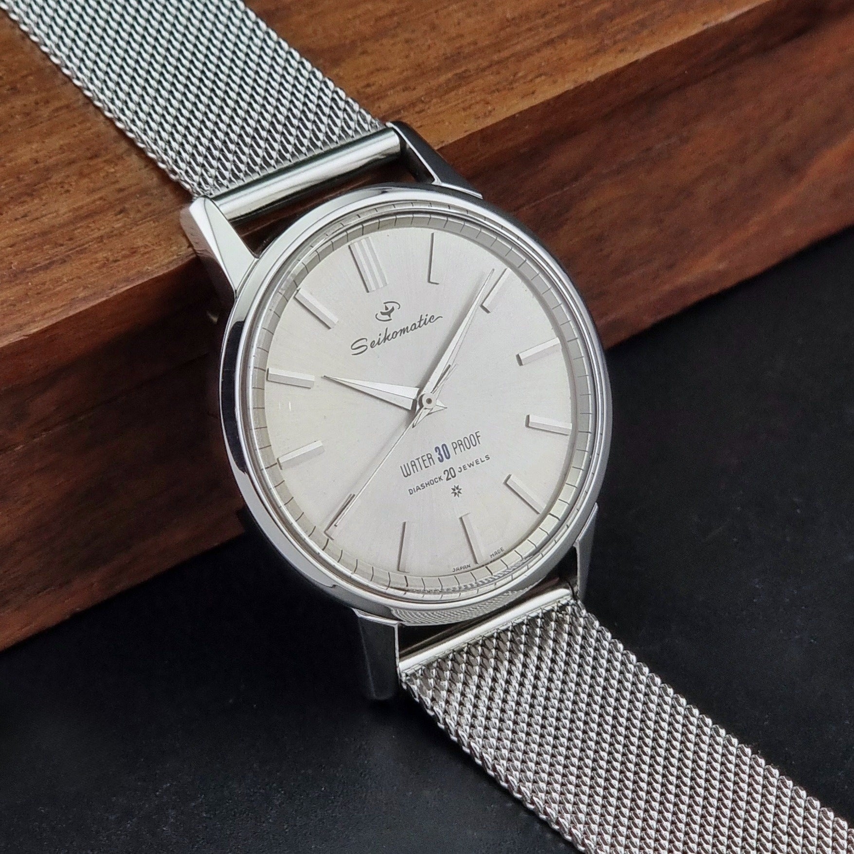 Vintage Seiko Wristwatch Seikomatic J13044E with mesh strap on a dark background side view