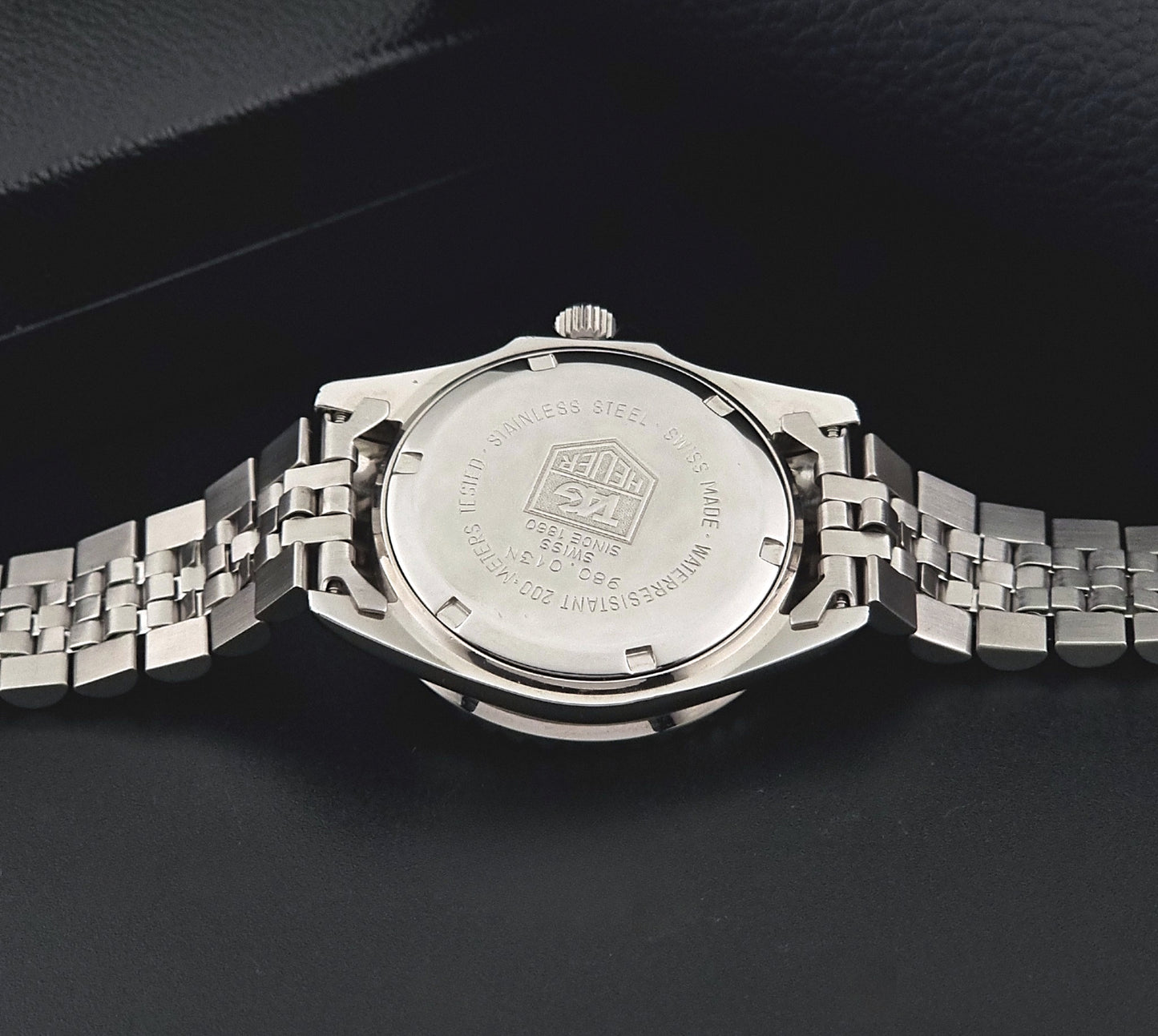 Vintage Tag Heuer Wristwatch Professional 1000 Quartz 980.013N with a black dial on a dark background back view