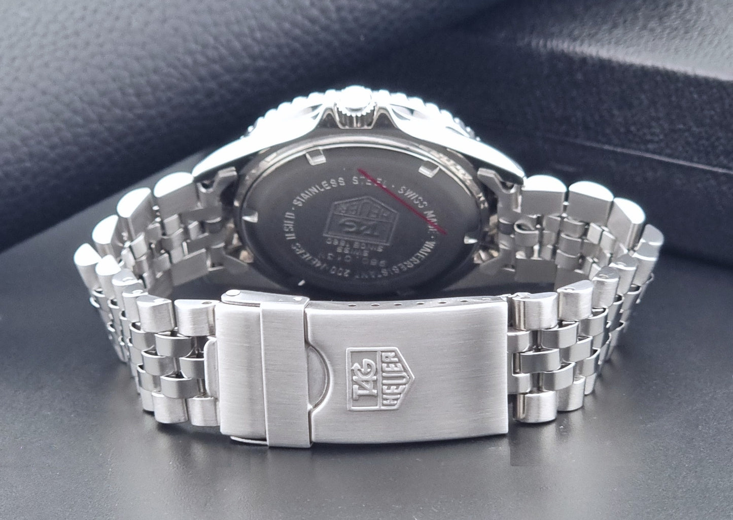 Vintage Tag Heuer Wristwatch Professional 1000 Quartz 980.013N with a black dial on a dark background clasp view