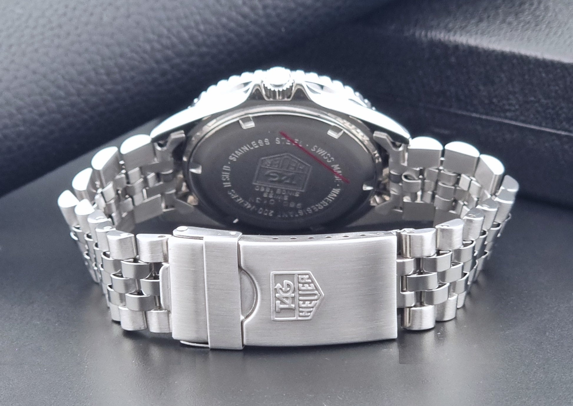Vintage Tag Heuer Wristwatch Professional 1000 Quartz 980.013N with a black dial on a dark background clasp view