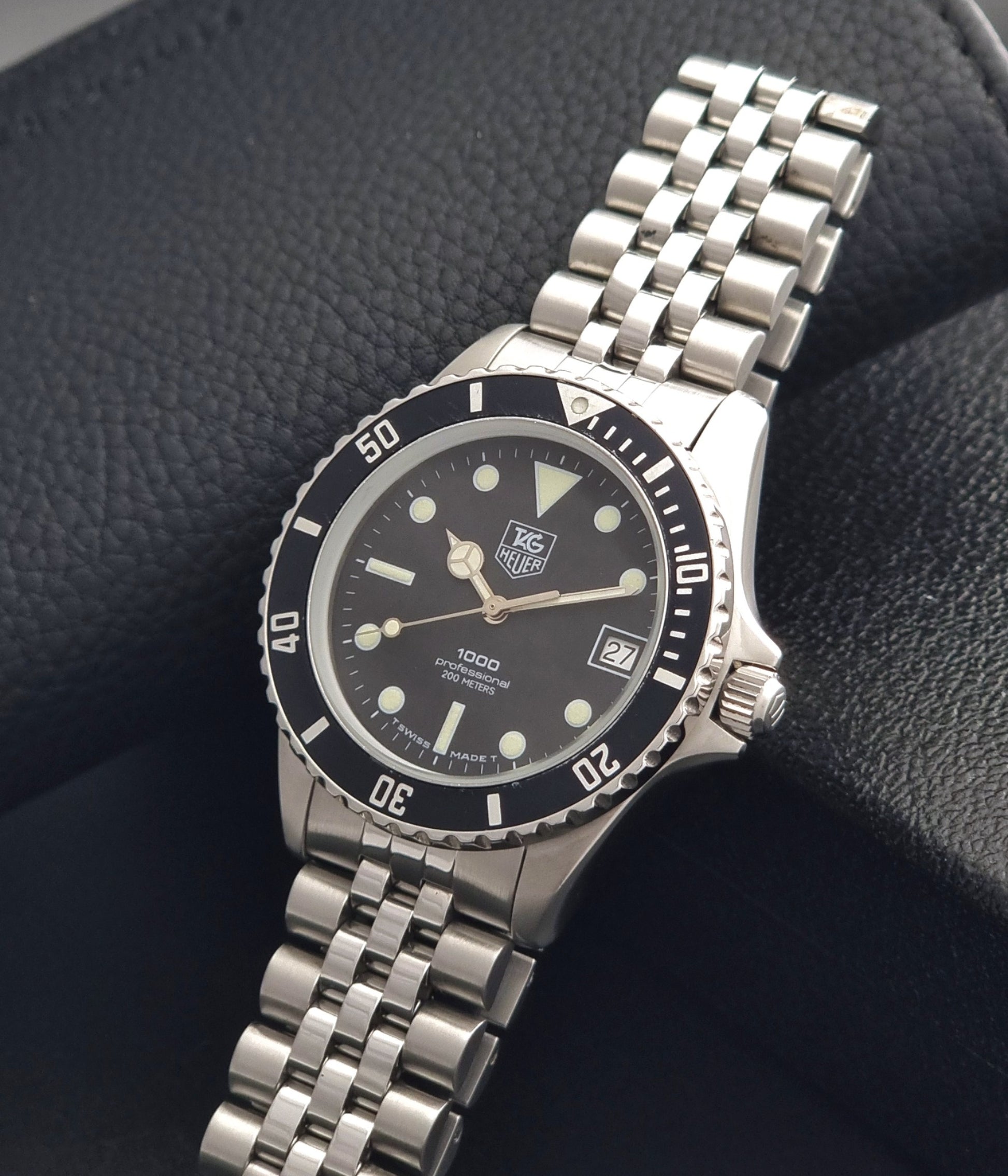 Vintage Tag Heuer Wristwatch Professional 1000 Quartz 980.013N with a black dial on a dark background crown view
