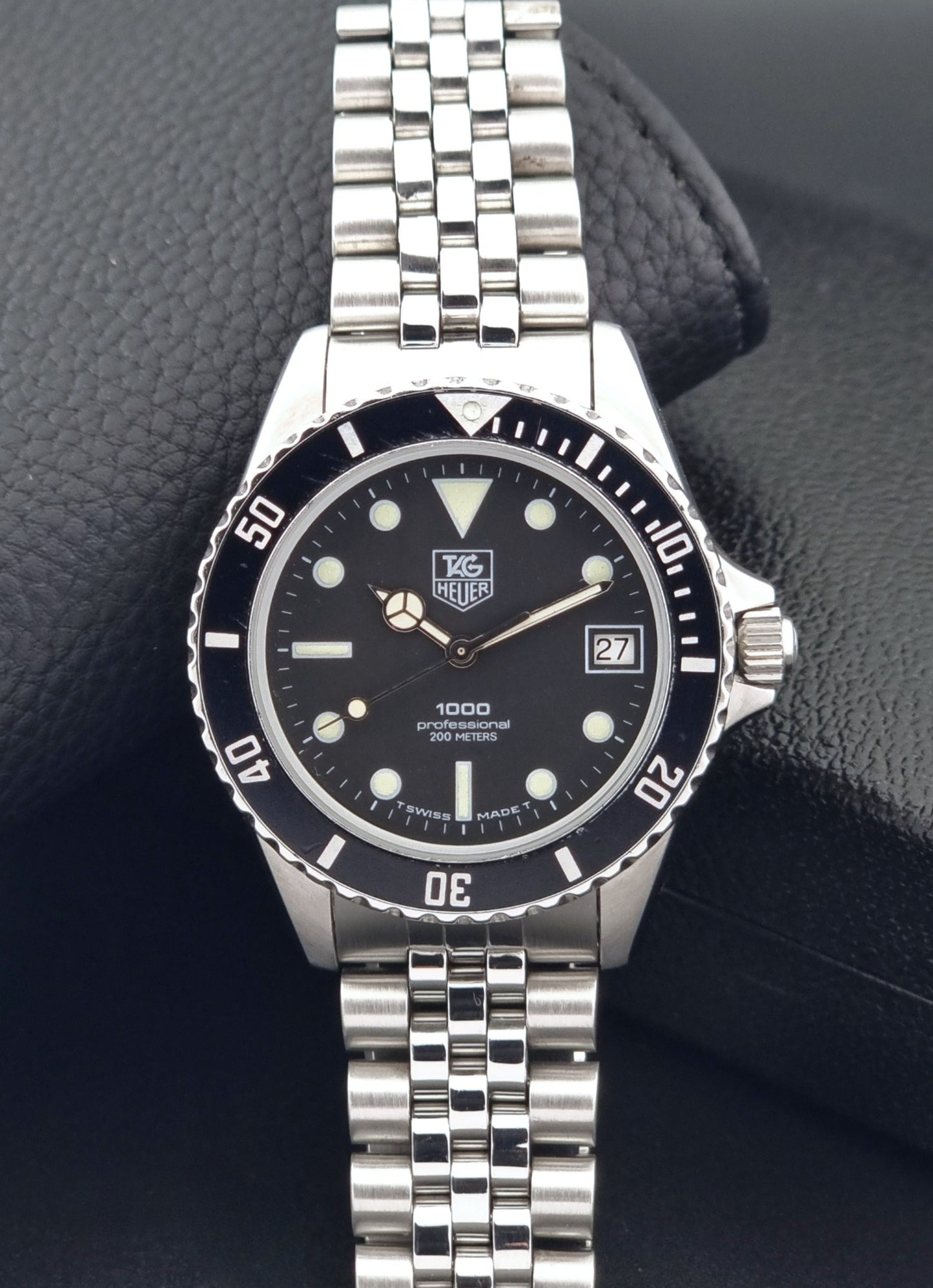 Vintage Tag Heuer Wristwatch Professional 1000 Quartz 980.013N with a black dial on a dark background dial view