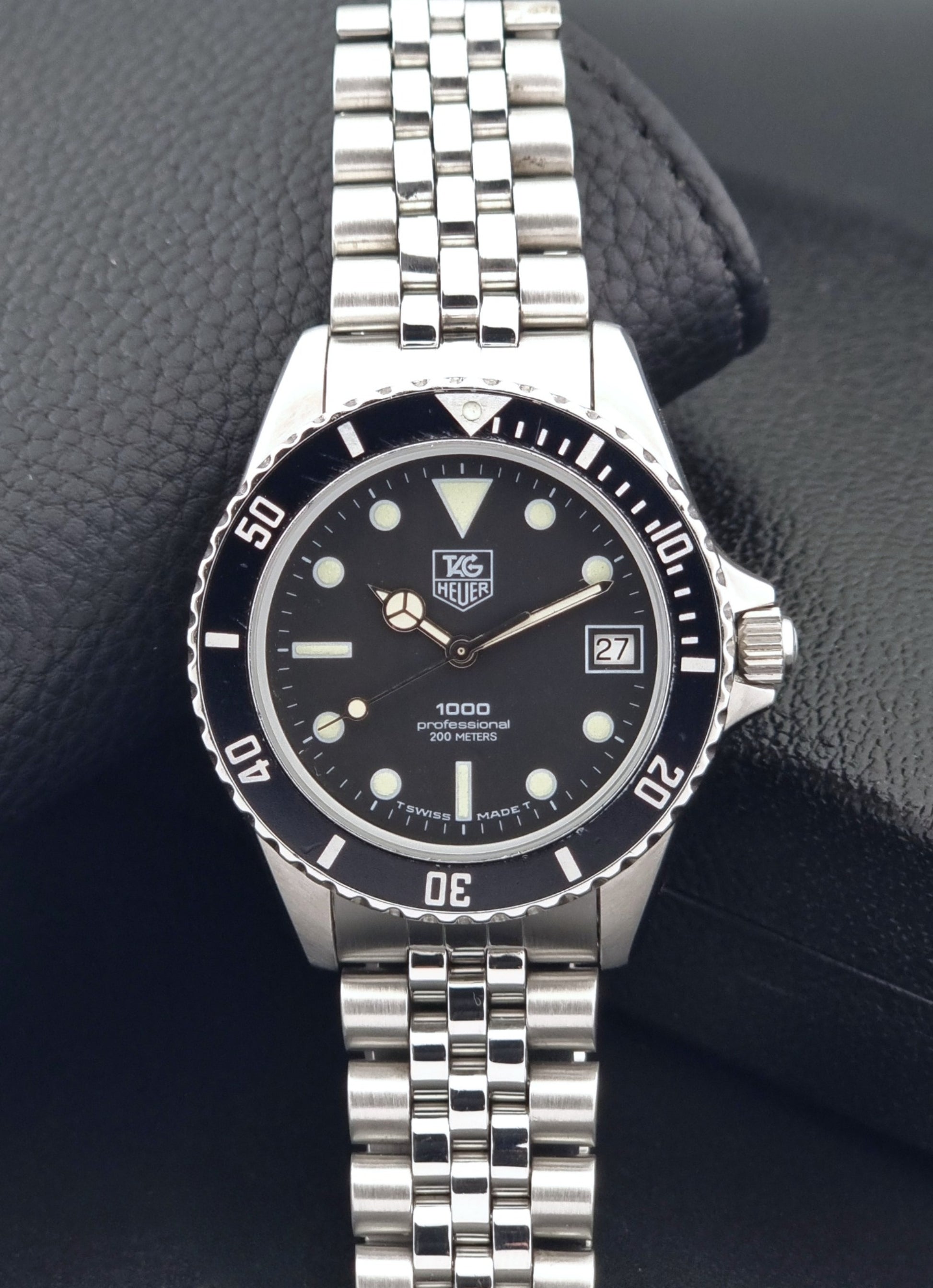 Vintage Tag Heuer Wristwatch Professional 1000 Quartz 980.013N with a black dial on a dark background dial view