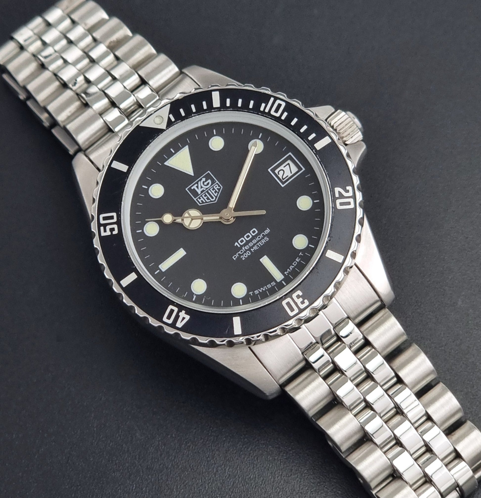 Vintage Tag Heuer Wristwatch Professional 1000 Quartz 980.013N with a black dial on a dark background close up dial view