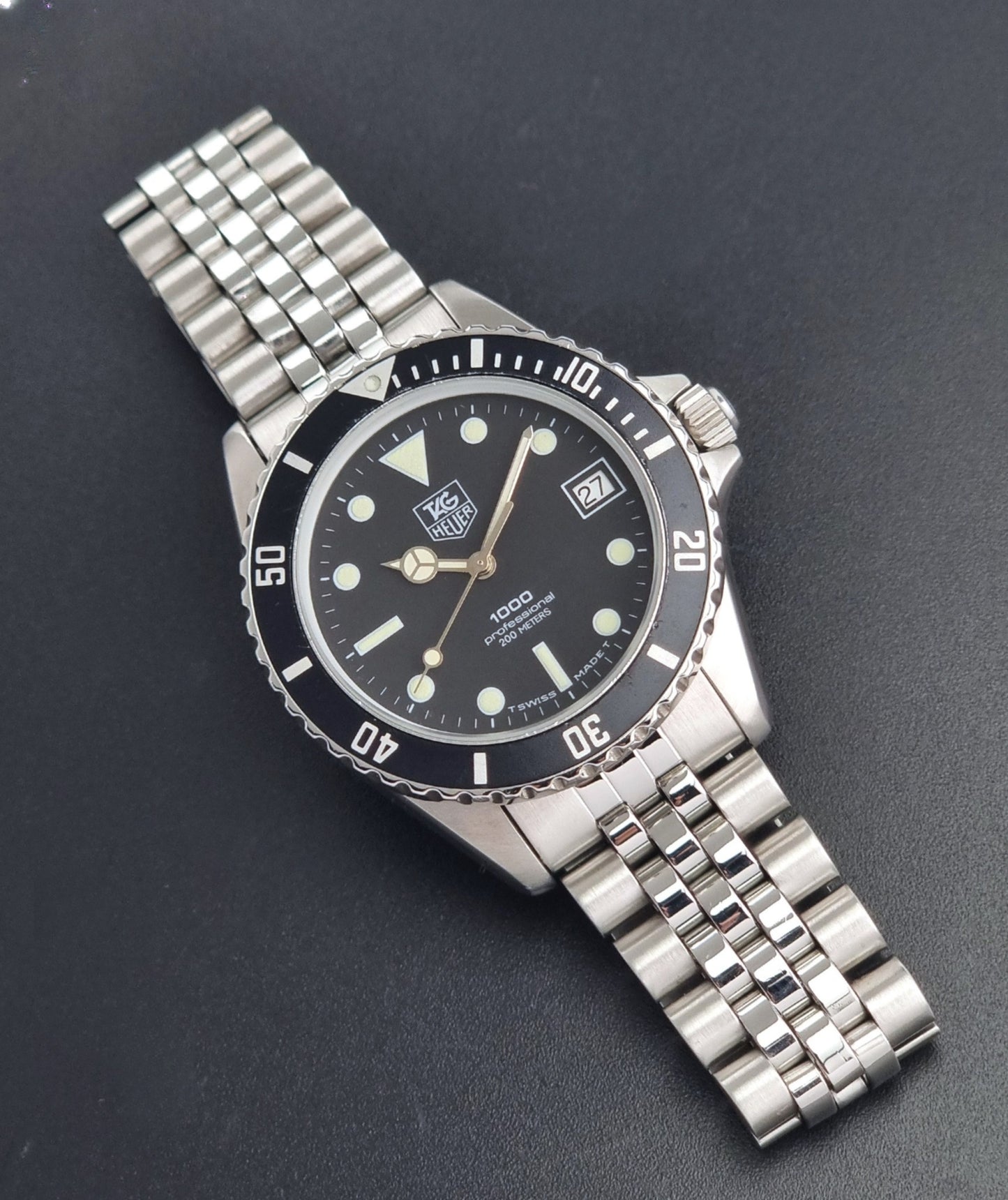 Vintage Tag Heuer Wristwatch Professional 1000 Quartz 980.013N with a black dial on a dark background dial