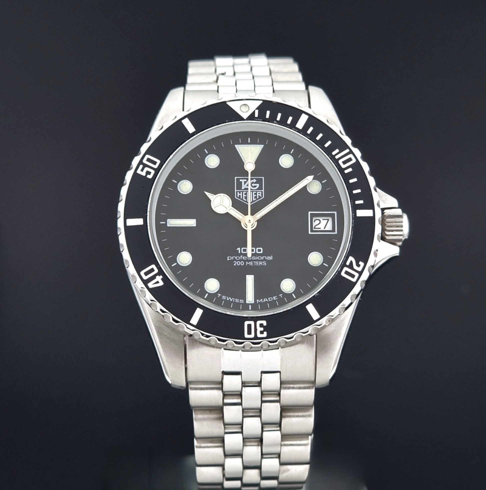 Vintage Tag Heuer Wristwatch Professional 1000 Quartz 980.013N with a black dial on a dark background close up dial view