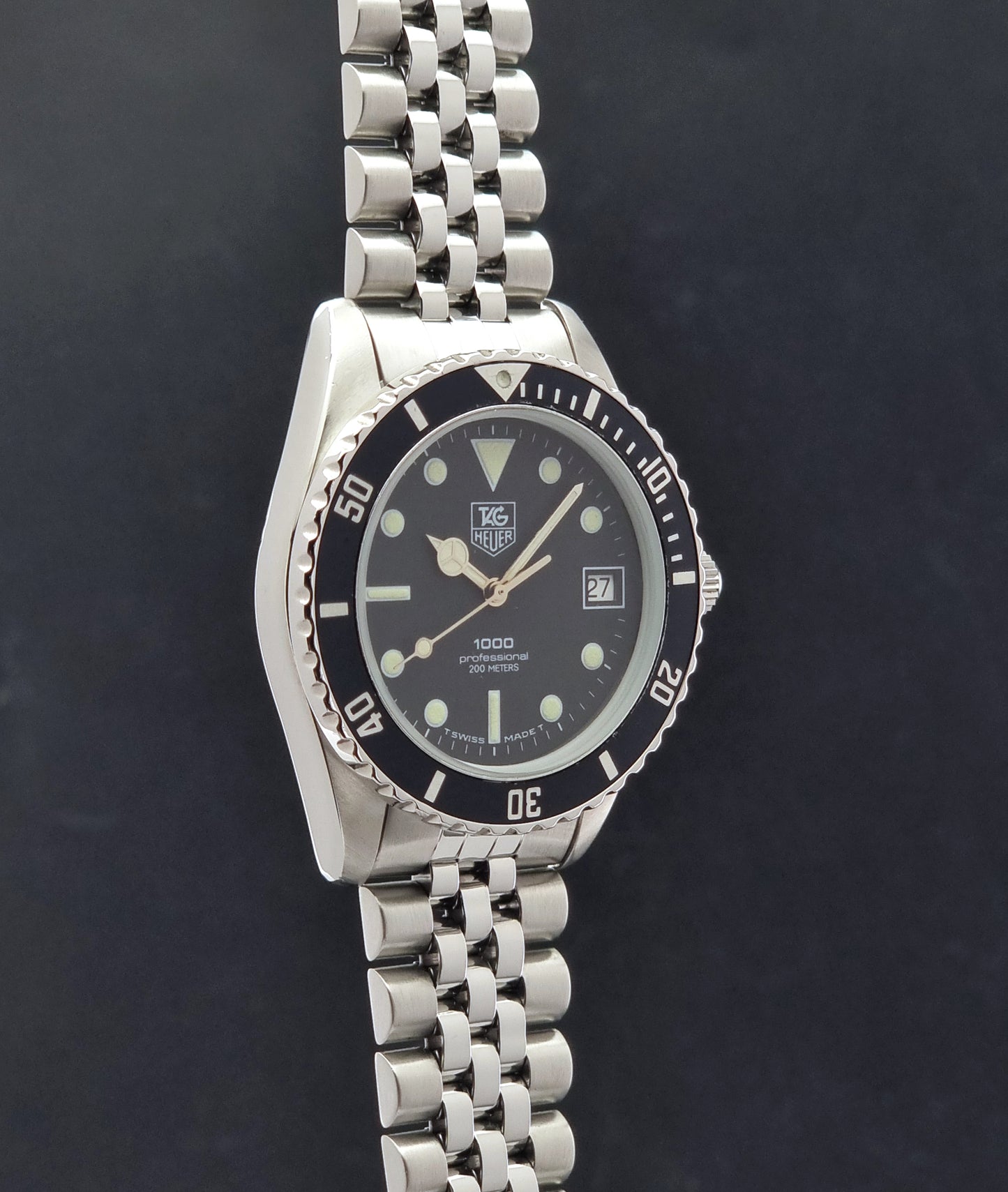 Vintage Tag Heuer Wristwatch Professional 1000 Quartz 980.013N with a black dial on a dark background side profile view