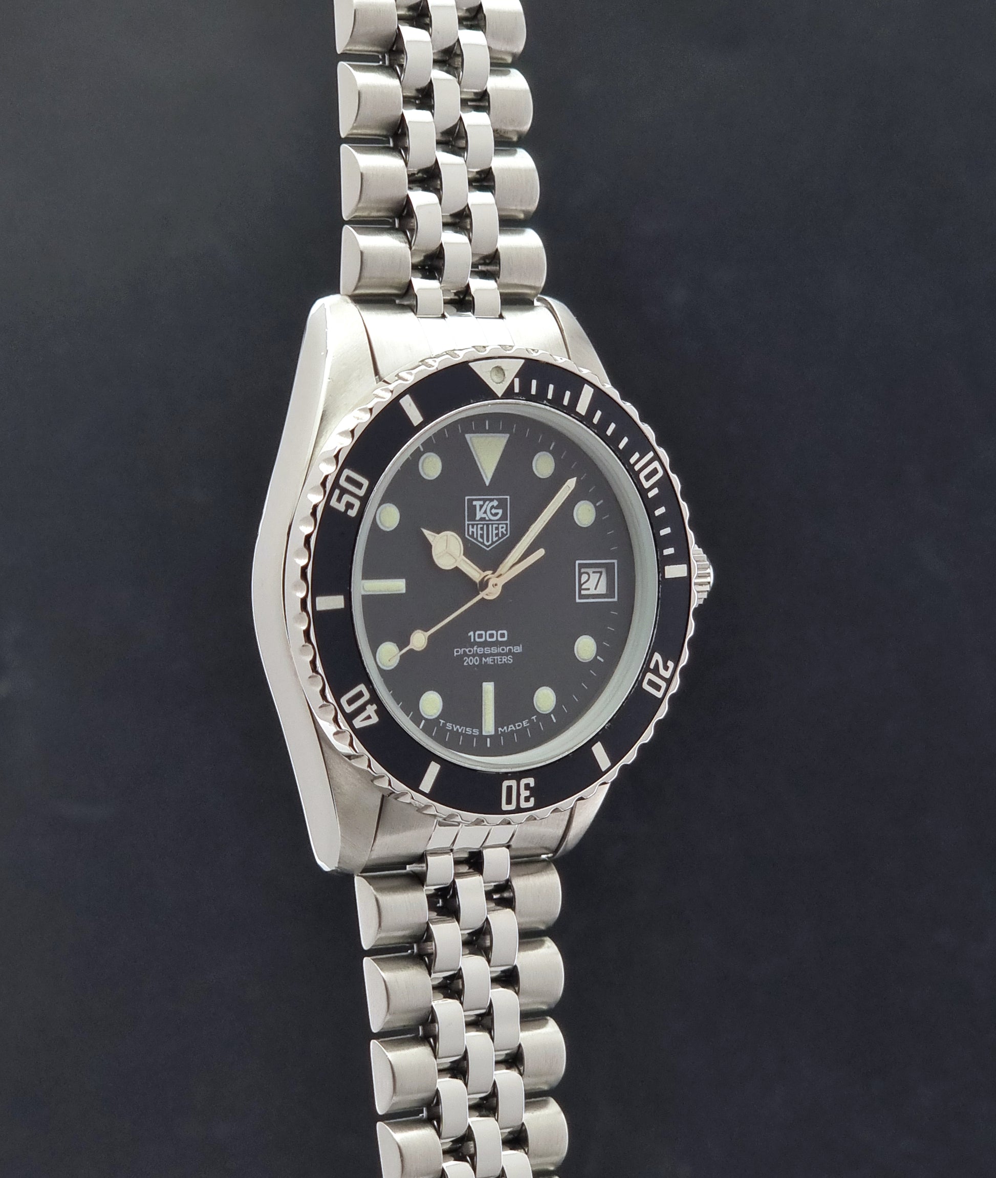 Vintage Tag Heuer Wristwatch Professional 1000 Quartz 980.013N with a black dial on a dark background side profile view