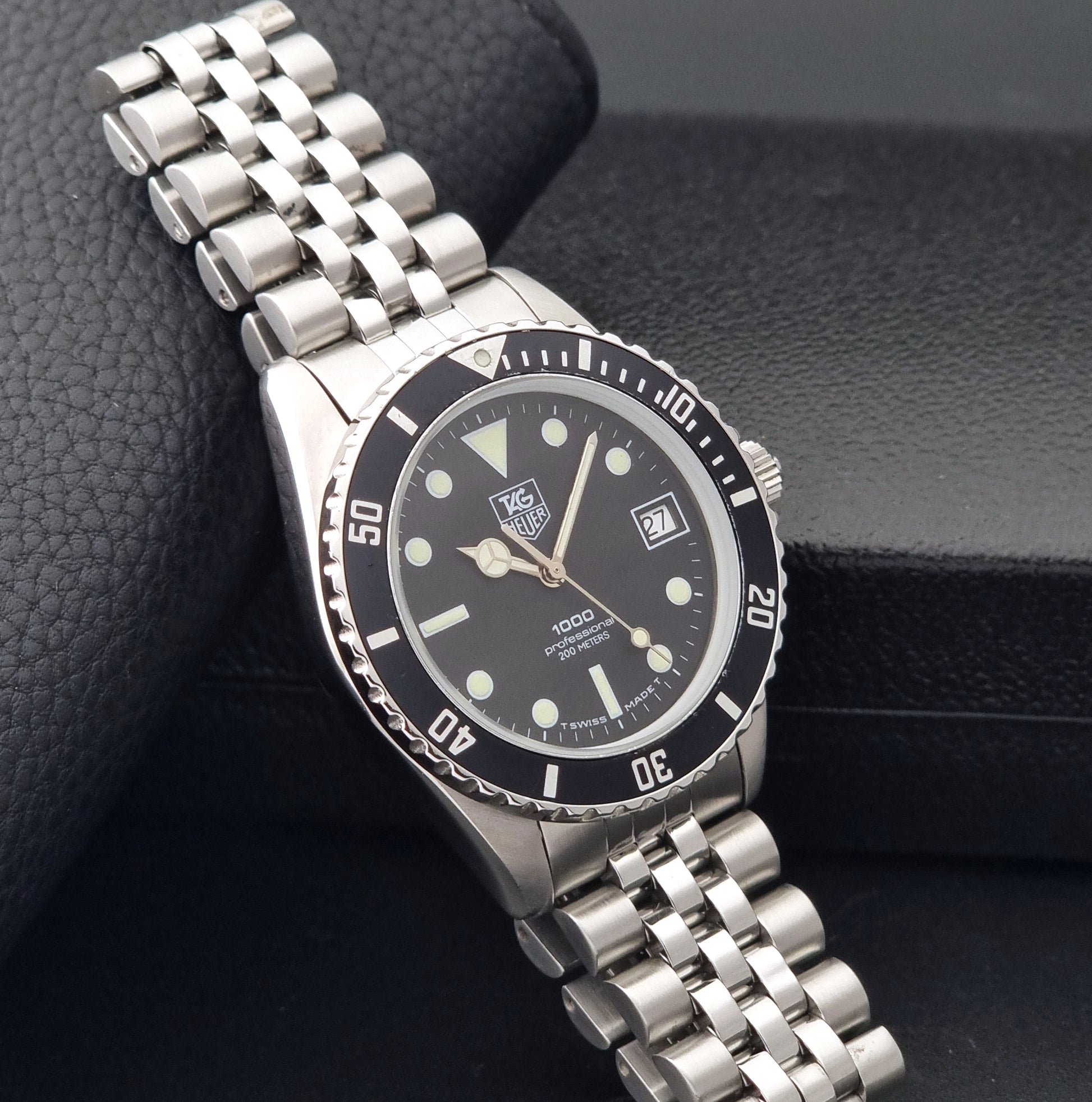 Vintage Tag Heuer Wristwatch Professional 1000 Quartz 980.013N with a black dial on a dark background side view