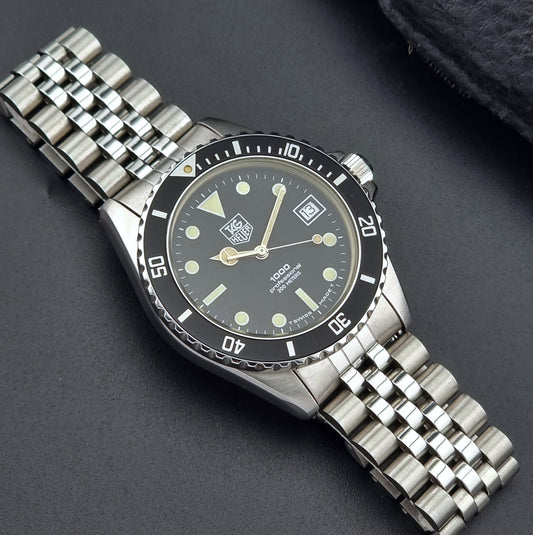 Vintage Tag Heuer watch Professional Quartz 1000 980.013N with a black dial on a dark gray background front
