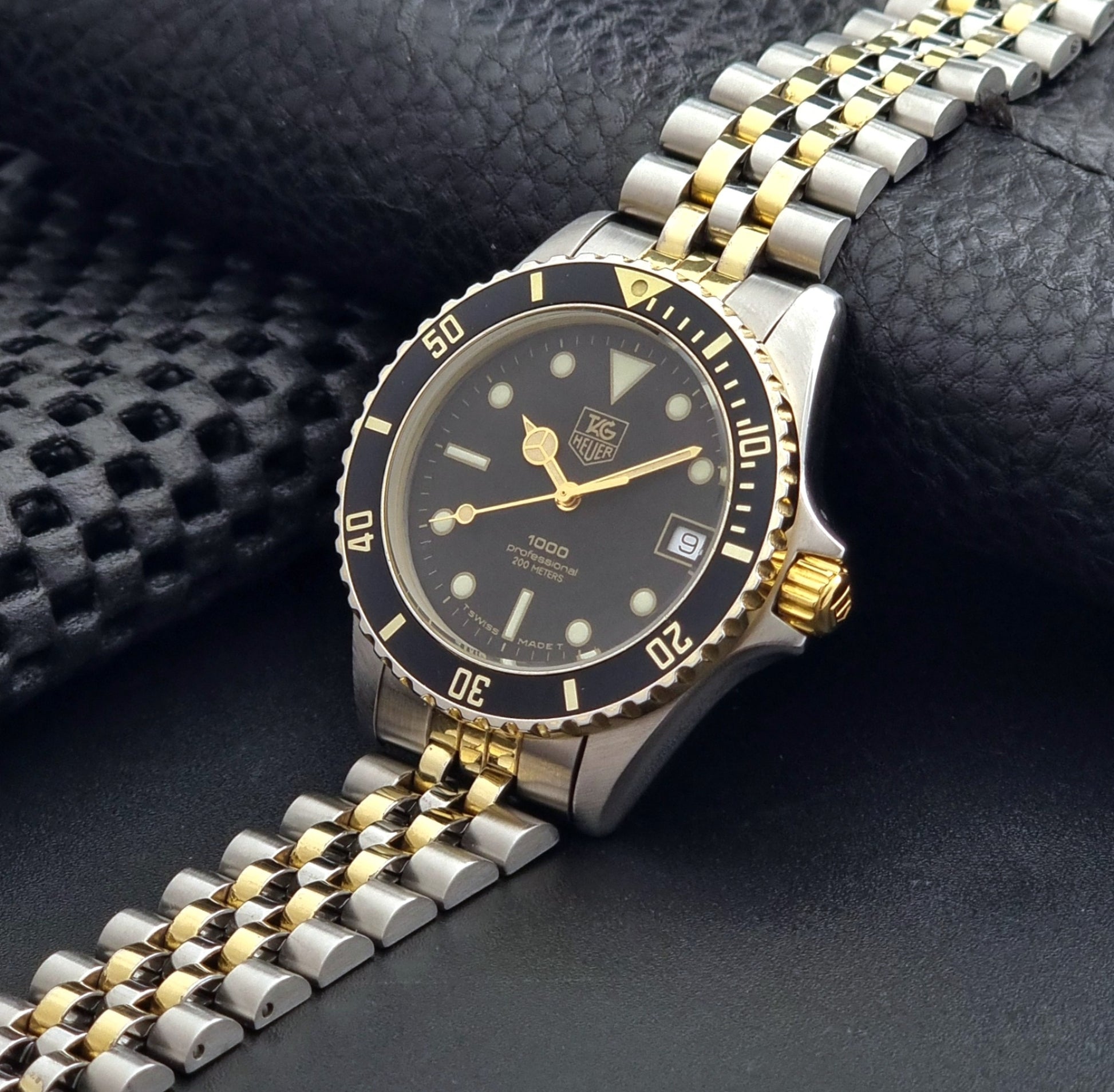 Vintage Tag Heuer watch Professional Quartz 1000 Diver 980.020N with silver and gold band on a dark background crown view