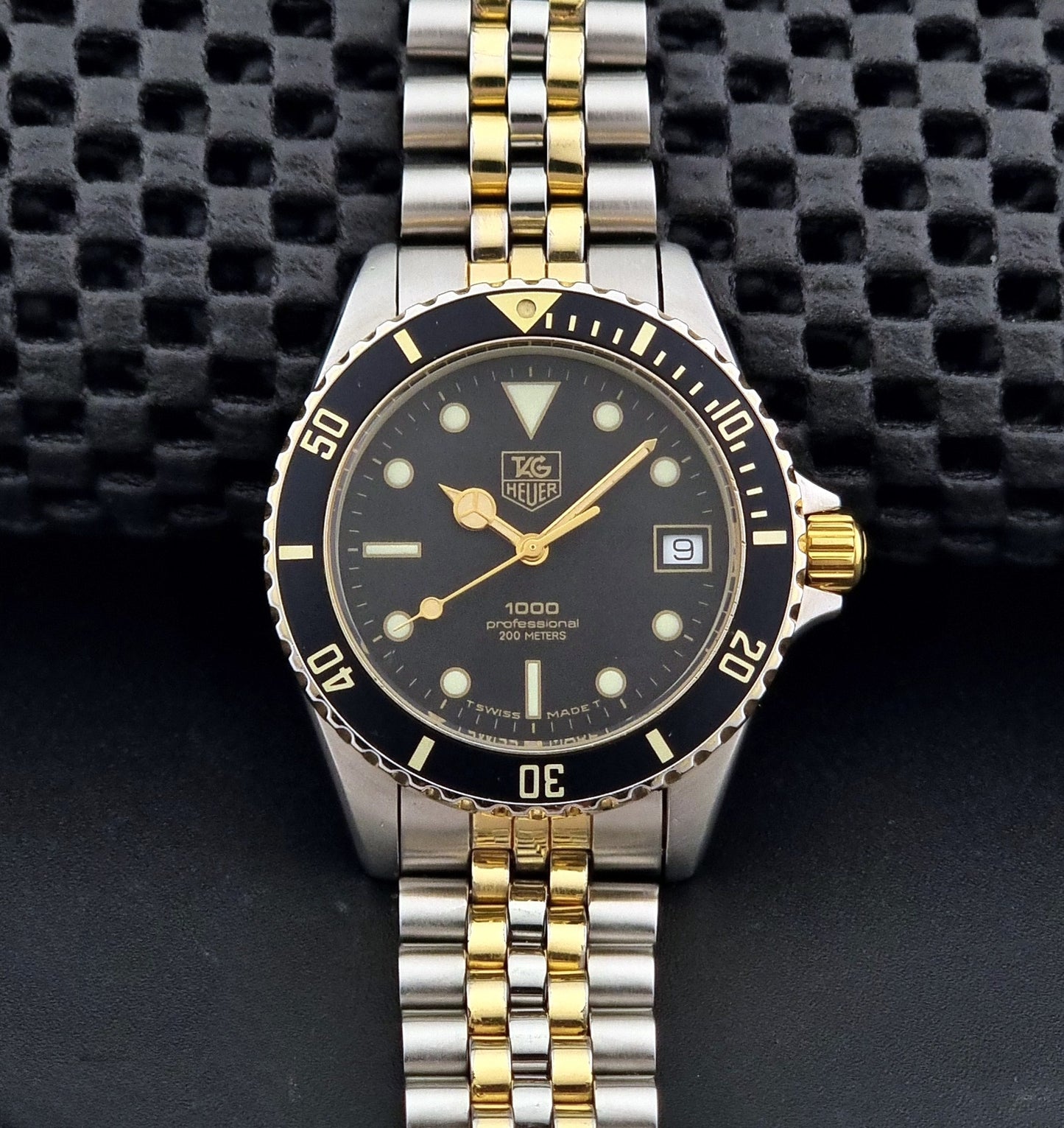 Vintage Tag Heuer watch Professional Quartz 1000 Diver 980.020N with silver and gold band on a dark background dial view