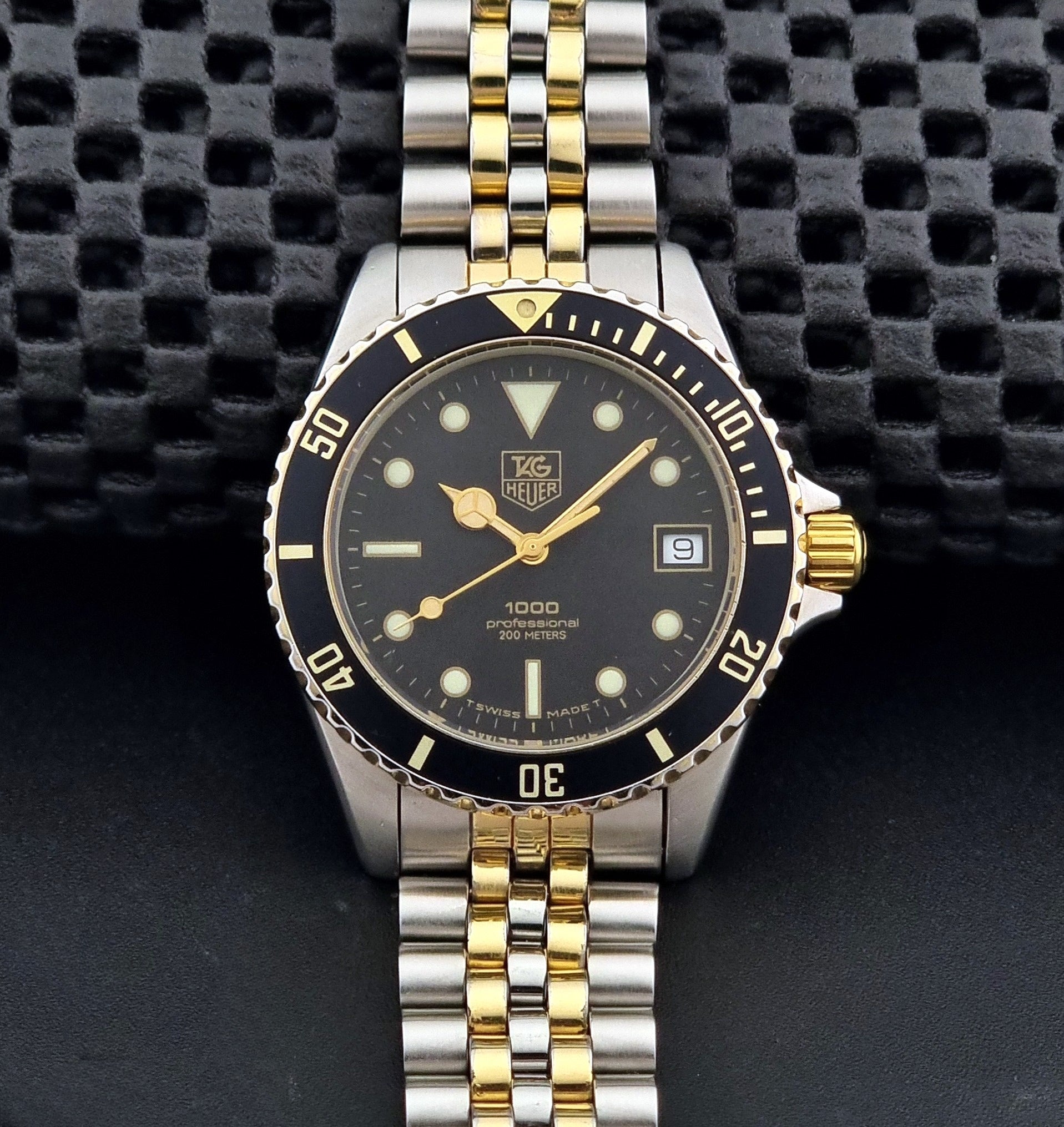 Vintage Tag Heuer watch Professional Quartz 1000 Diver 980.020N with silver and gold band on a dark background dial view