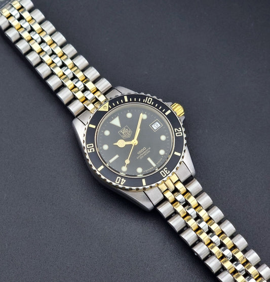 Vintage Tag Heuer watch Professional Quartz 1000 Diver 980.020N with silver and gold band on a dark background dial