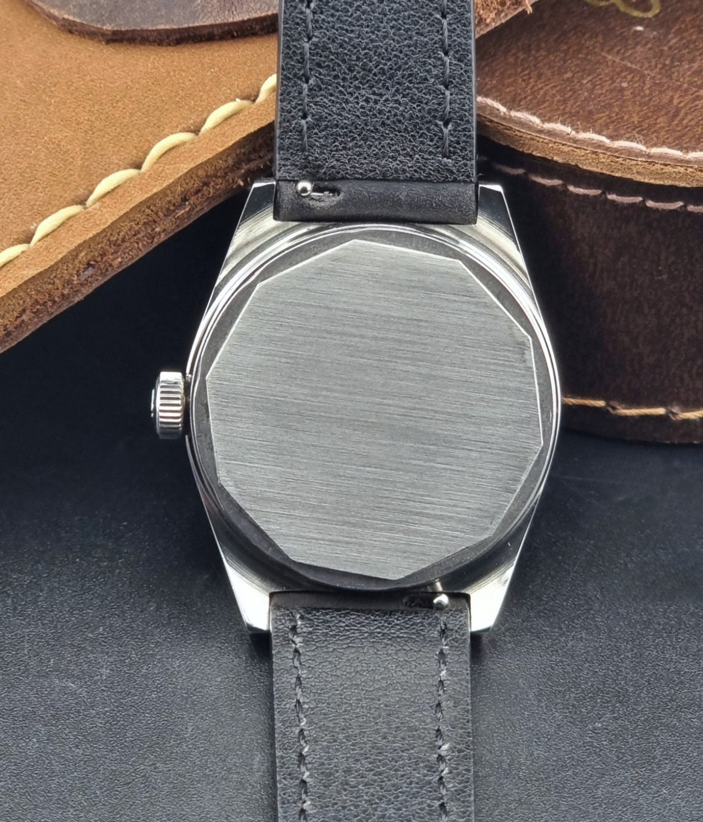 Vintage Tissot Wristwatch 41620 PR 516 with black leather strap on a grey surface case back view
