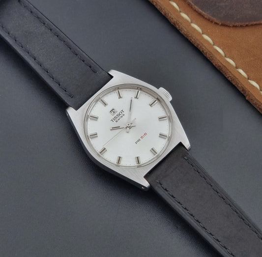 Vintage Tissot Wristwatch 41620 PR 516 with black leather strap on a grey surface dial