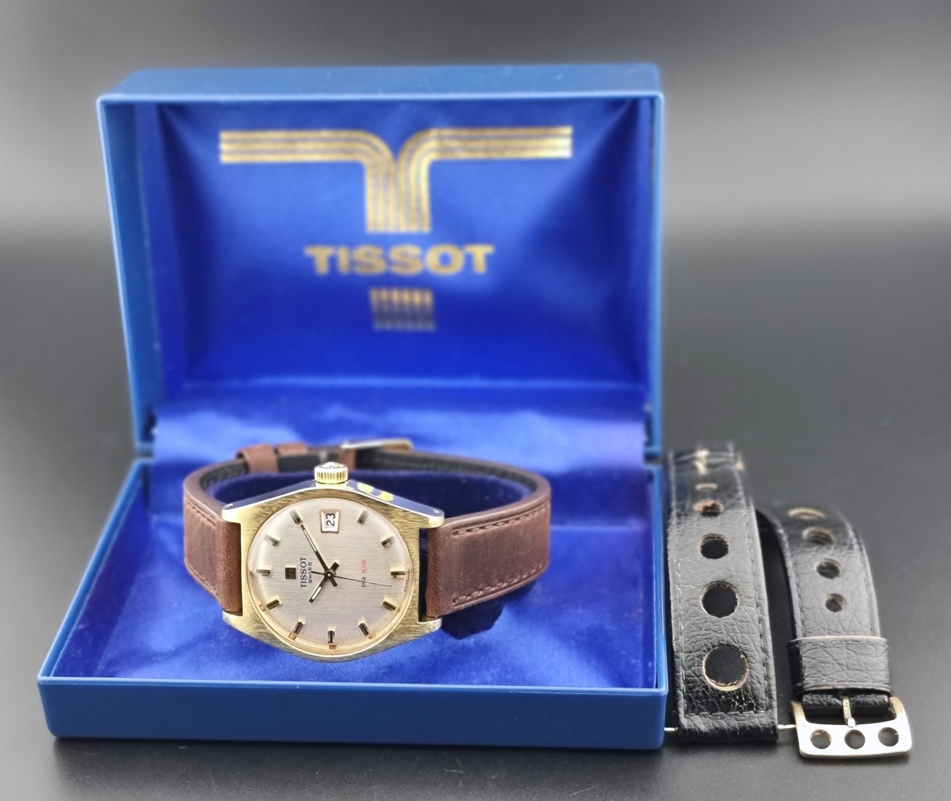 Vintage Tissot Watch 41620 PR 516 in Gold with brown leather strap on a green background box view