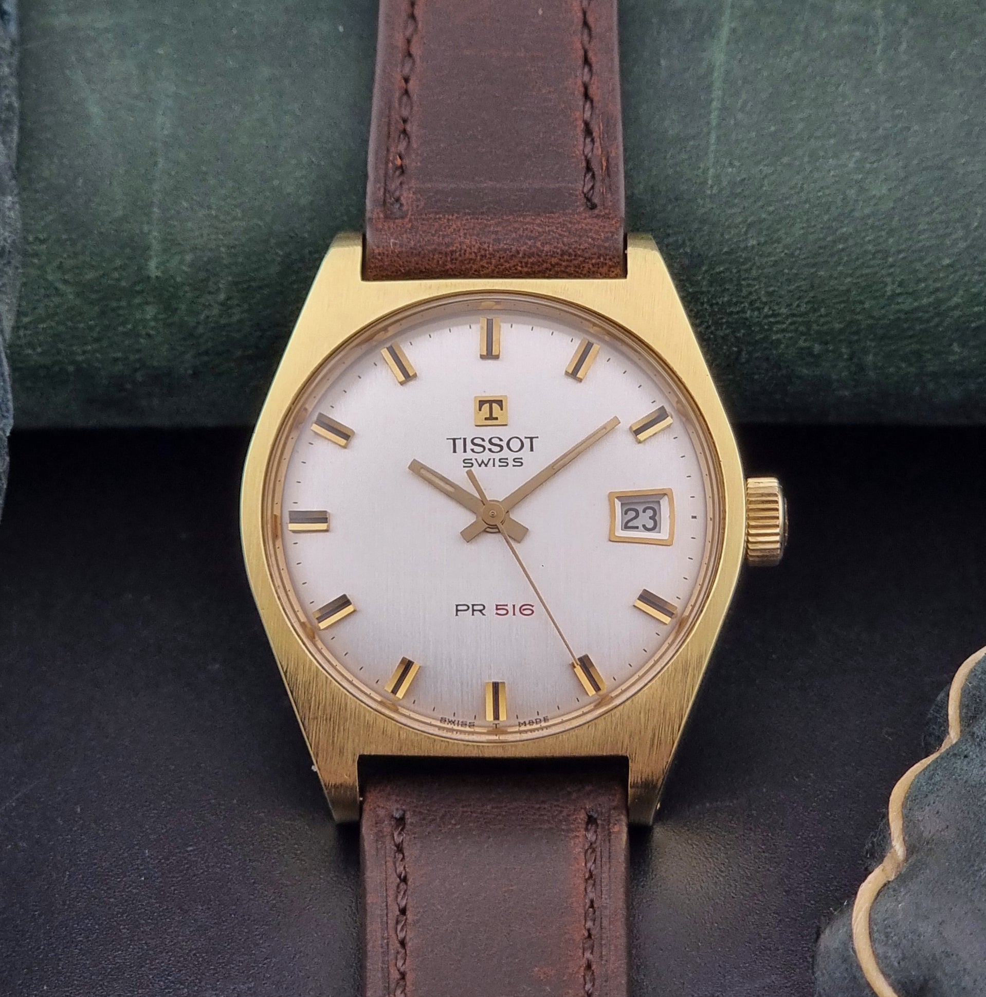 Vintage Tissot Watch 41620 PR 516 in Gold with brown leather strap on a green background dial view