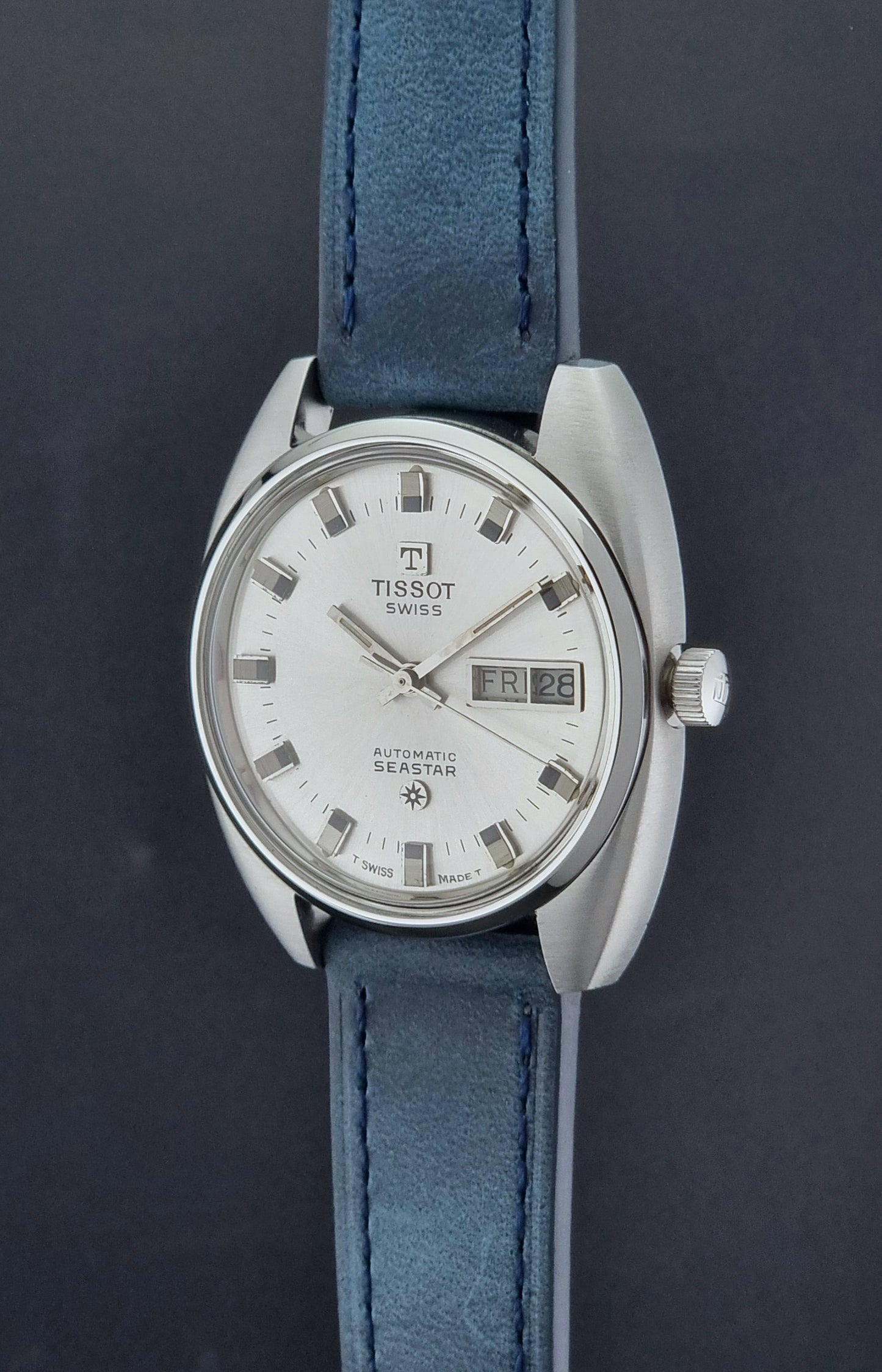 Vintage Tissot Wristwatch Seastar 46660-4Xh with blue strap on a dark surface crown profile view