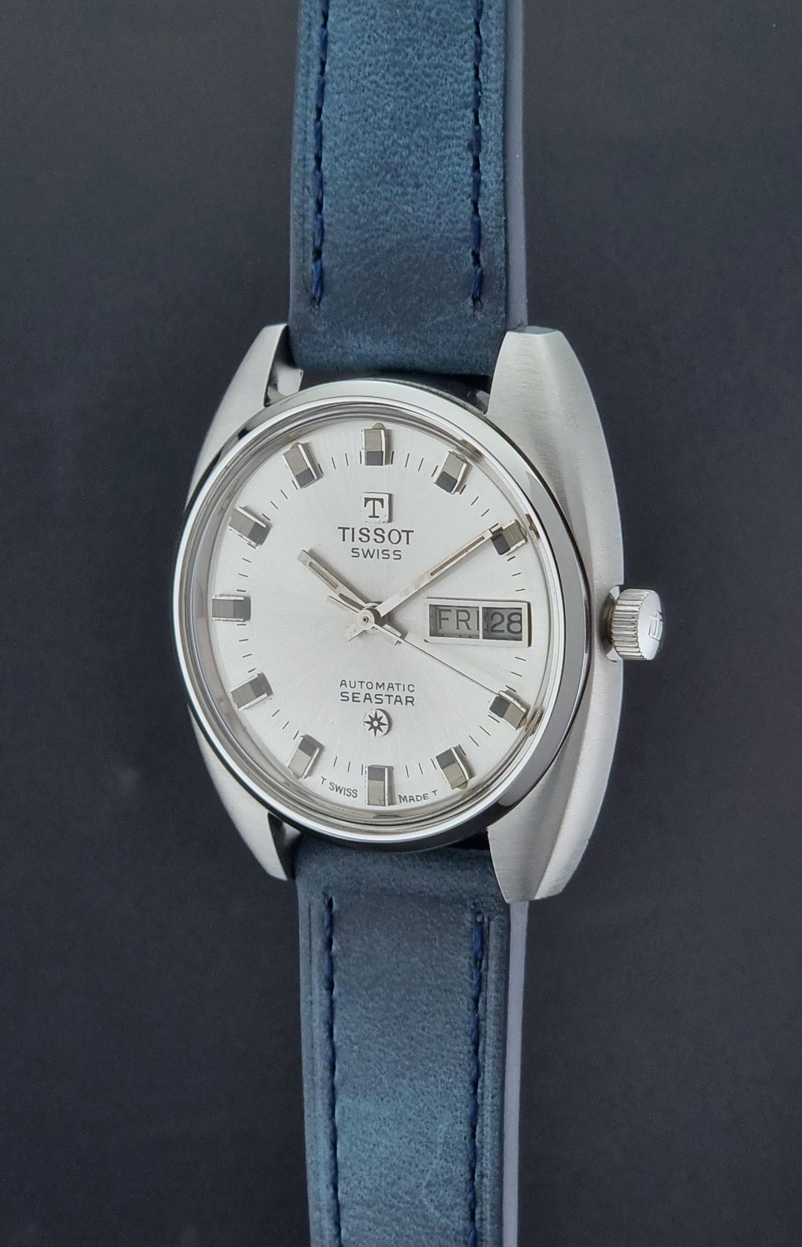 Vintage Tissot Wristwatch Seastar 46660-4Xh with blue strap on a dark surface crown profile view