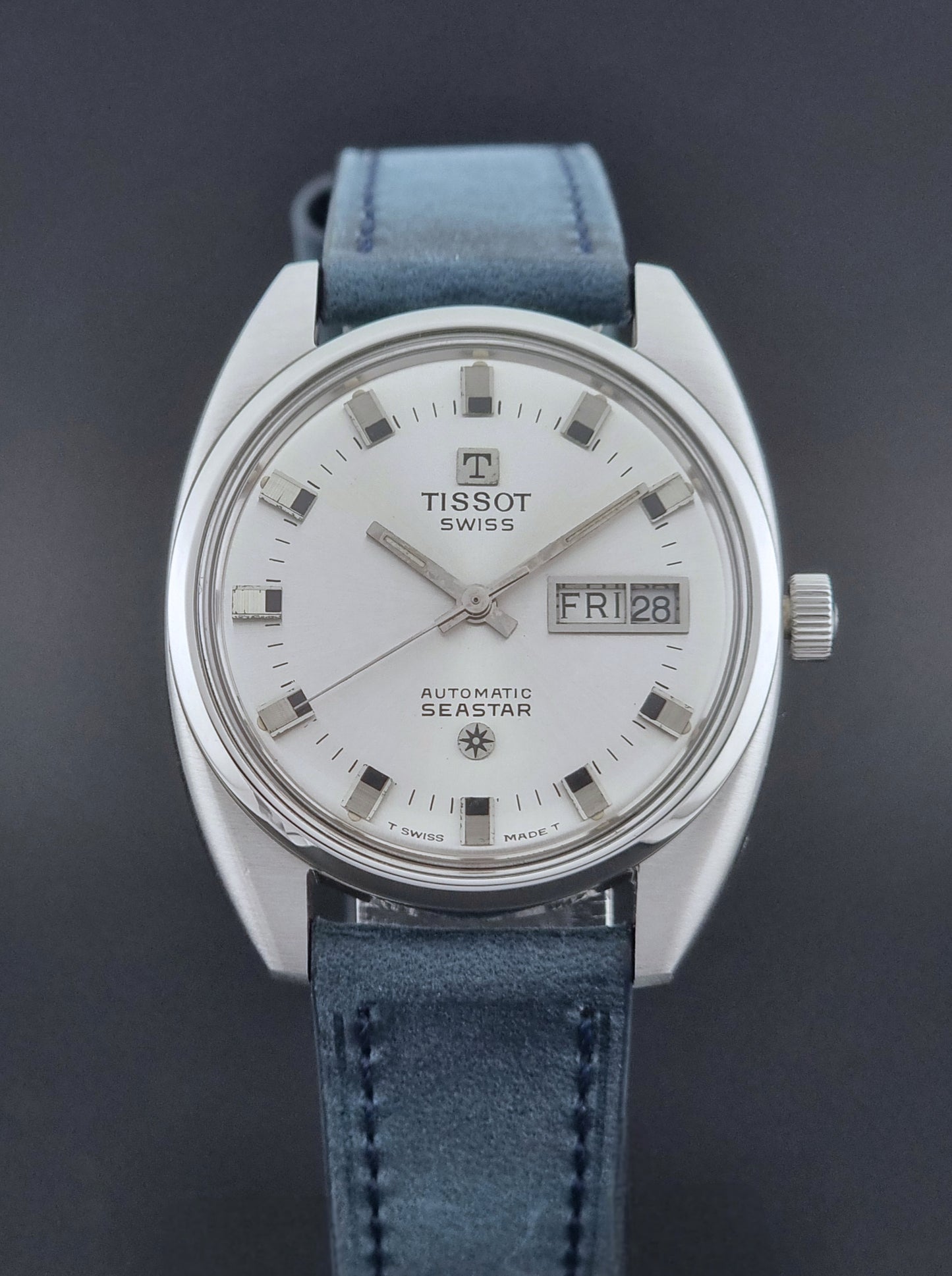 Vintage Tissot Wristwatch Seastar 46660-4Xh with blue strap on a dark surface dial view