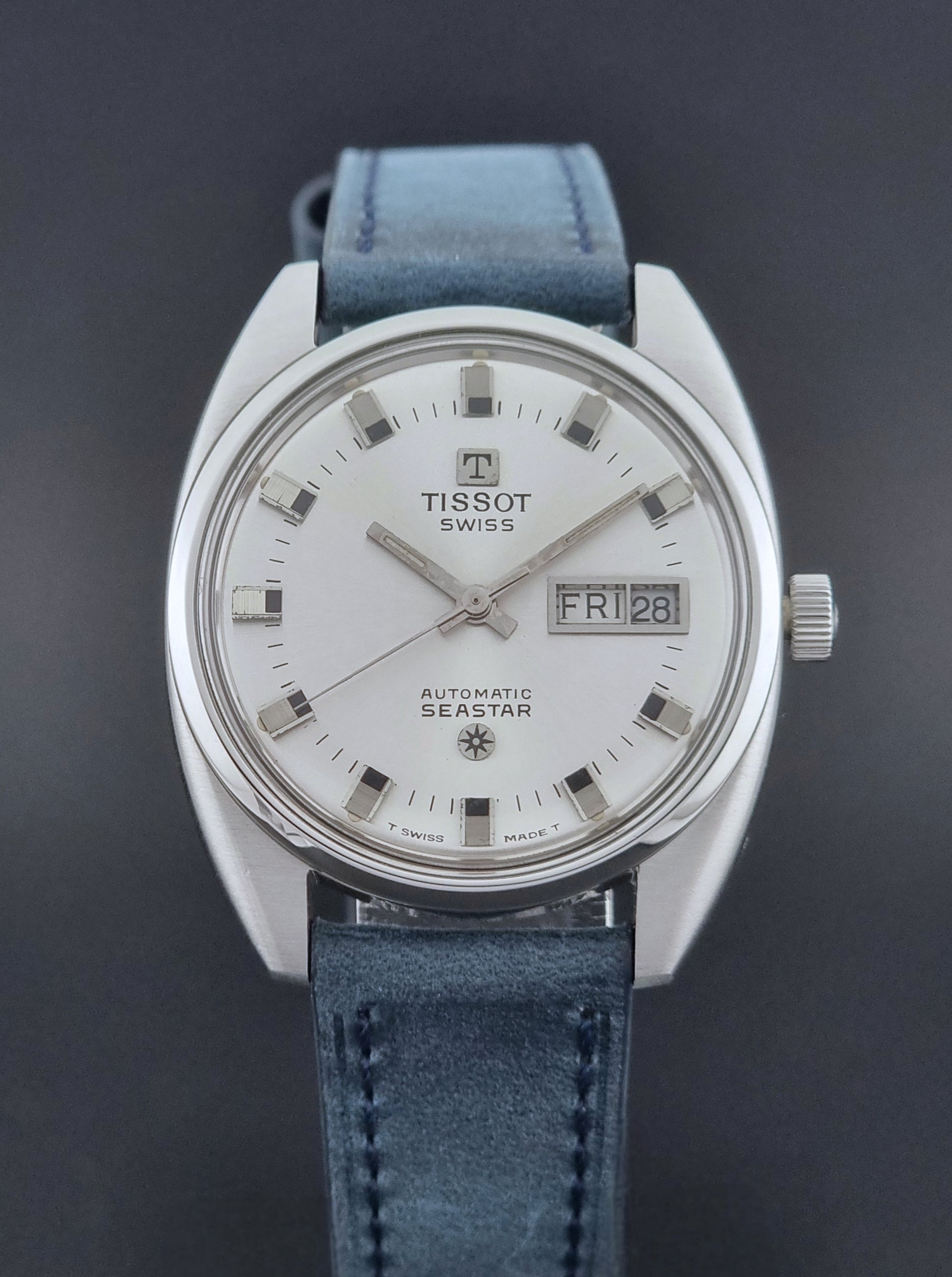 Vintage Tissot Wristwatch Seastar 46660-4Xh with blue strap on a dark surface dial view