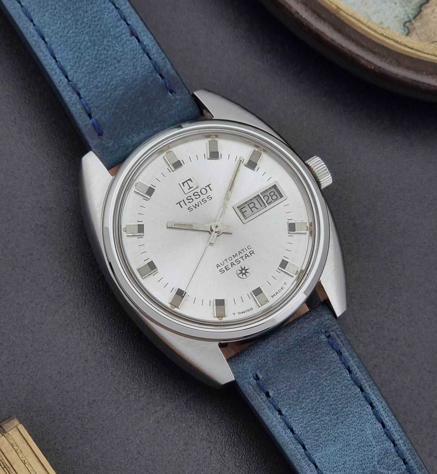 Vintage Tissot Wristwatch Seastar 46660-4Xh with blue strap on a dark surface close dial view