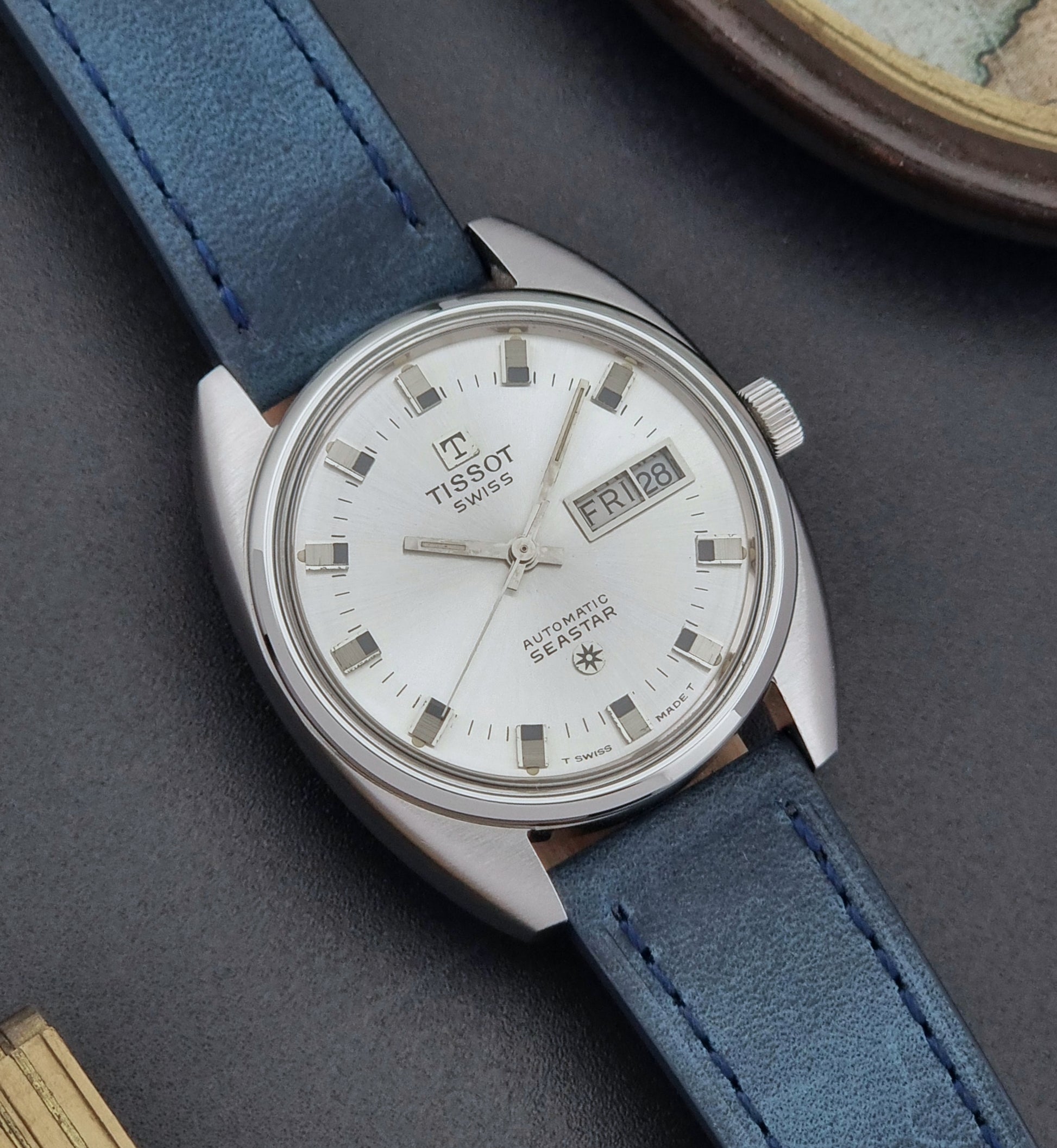 Vintage Tissot Wristwatch Seastar 46660-4Xh with blue strap on a dark surface close dial view