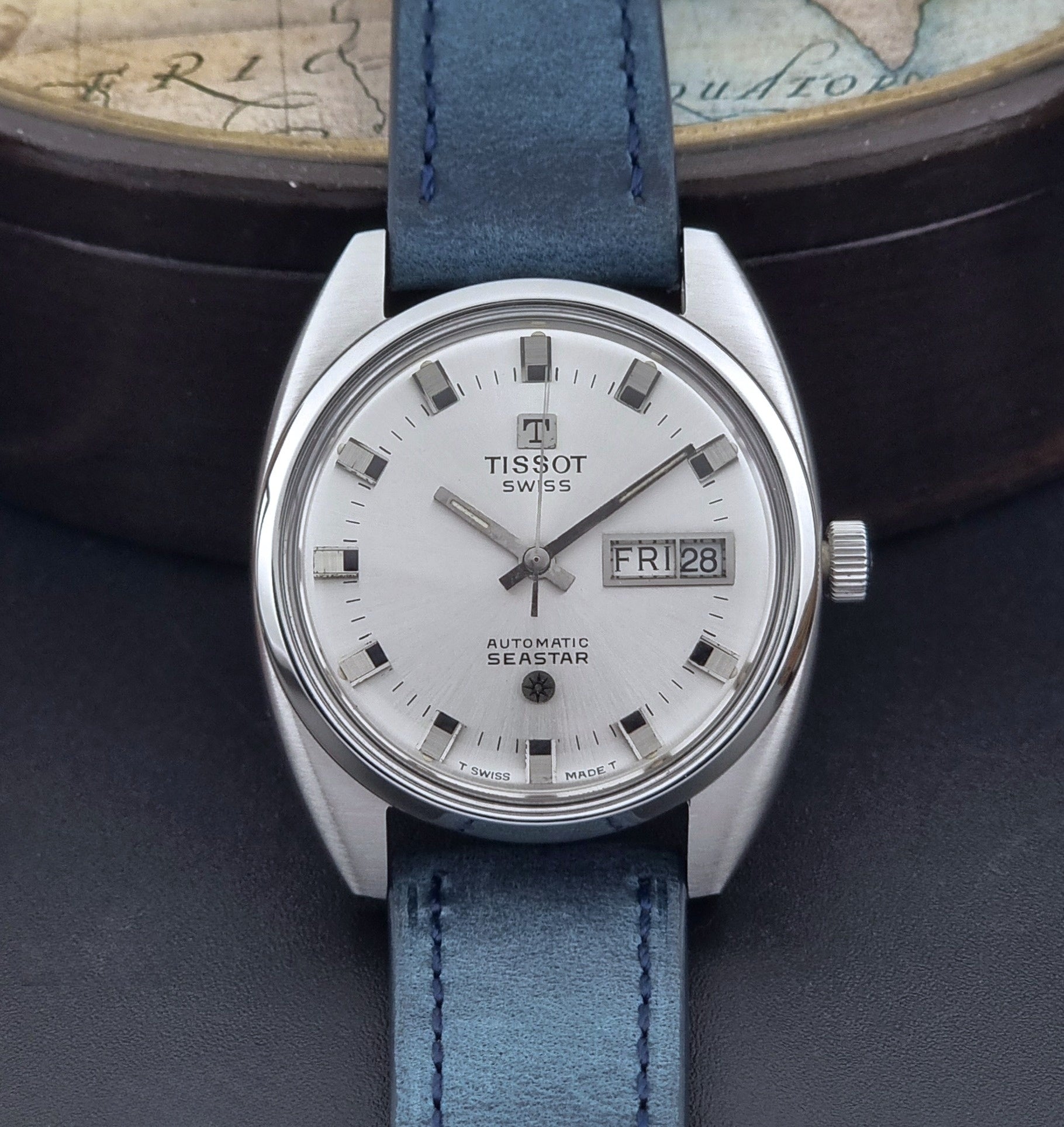 Vintage Tissot Wristwatch Seastar 46660-4Xh with blue strap on a dark surface close up dial view