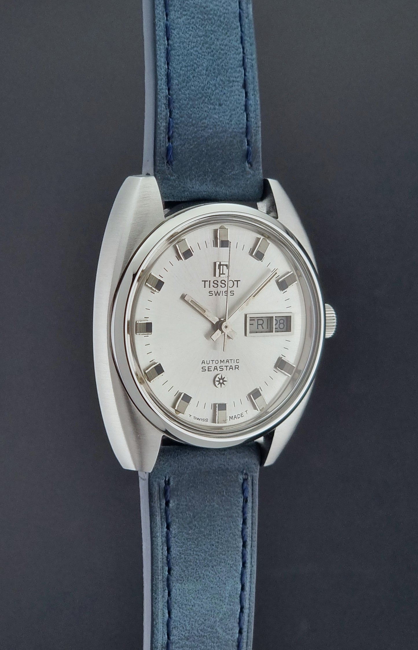 Vintage Tissot Wristwatch Seastar 46660-4Xh with blue strap on a dark surface side profile view