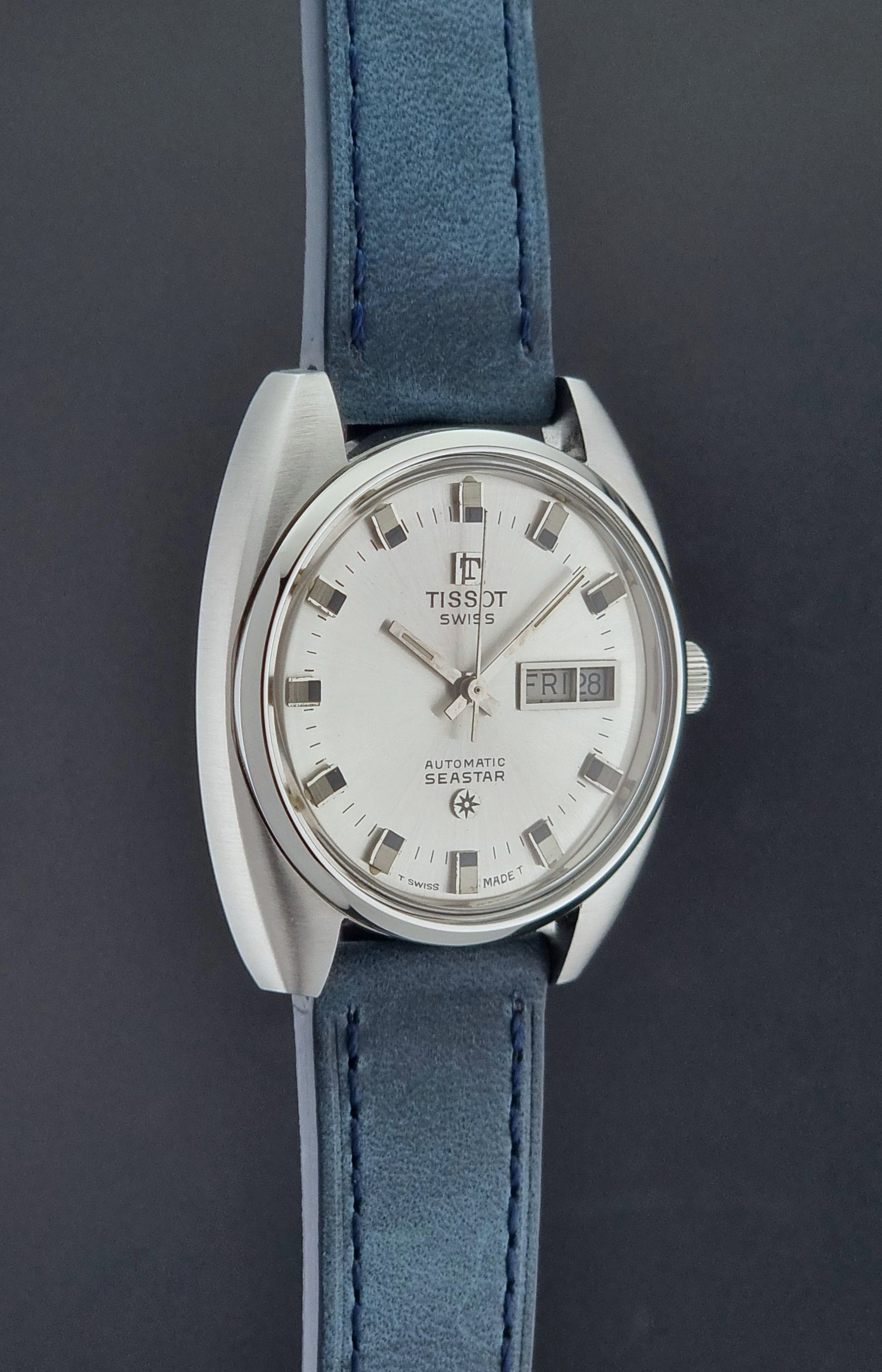 Vintage Tissot Wristwatch Seastar 46660-4Xh with blue strap on a dark surface side profile view