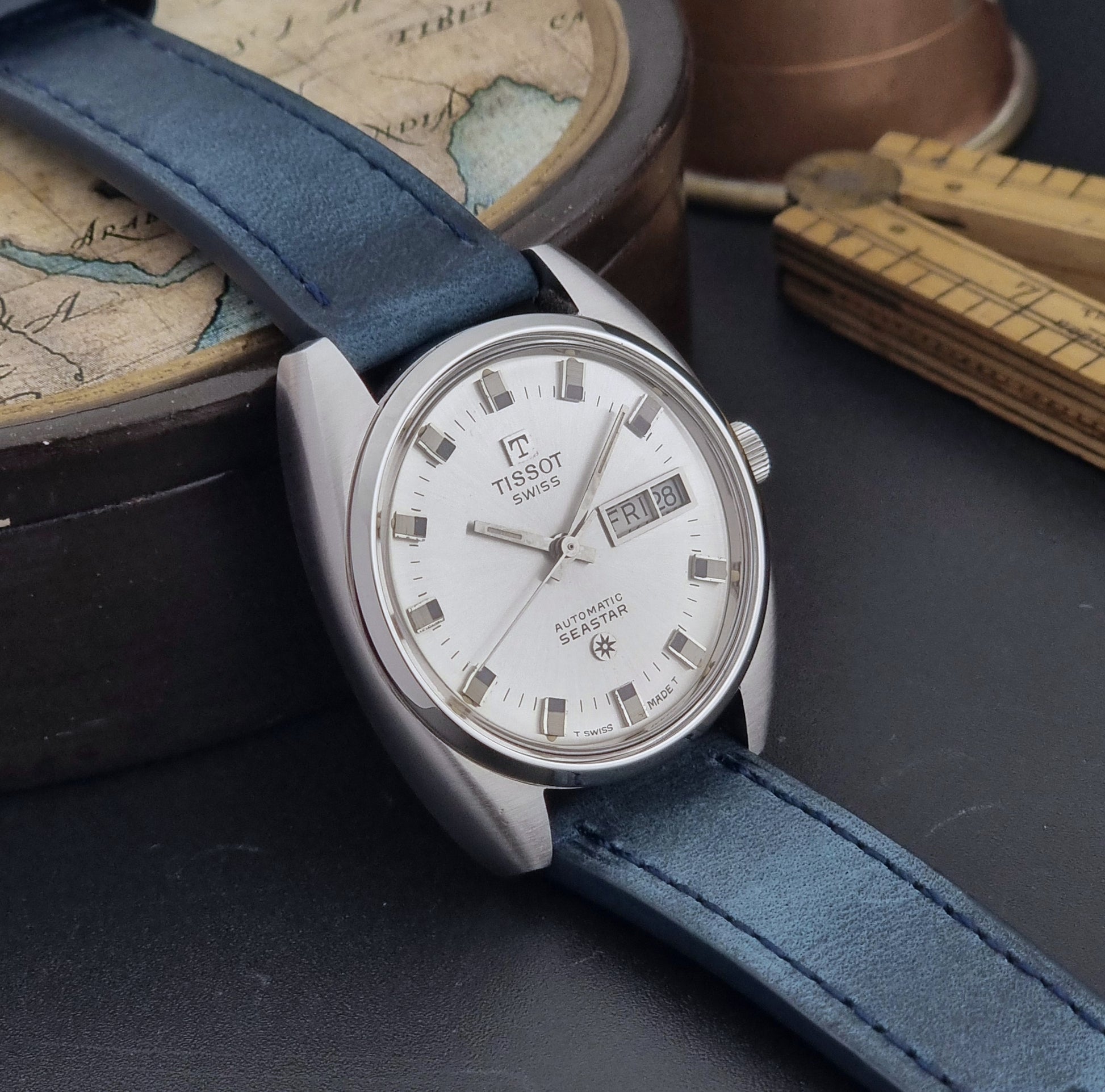 Vintage Tissot Wristwatch Seastar 46660-4Xh with blue strap on a dark surface side view