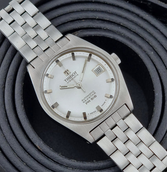 Tissot Seastar Visodate watch with a white dial on a textured black background