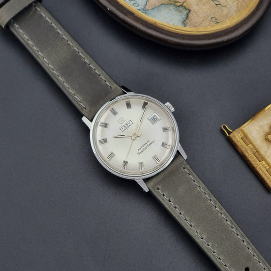 Vintage Tissot Watch Seastar Seven Visodate 43524 with grey leather strap on a dark surface front
