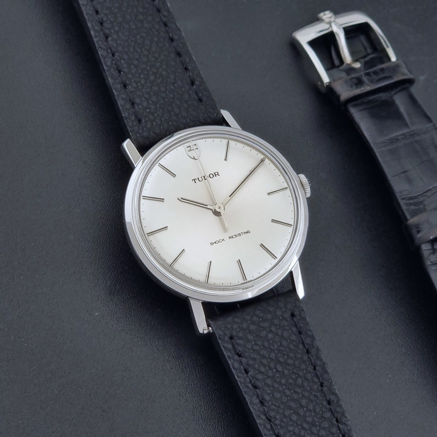 Vintage Tudor 9800 watch with black leather strap on a dark gray background front 