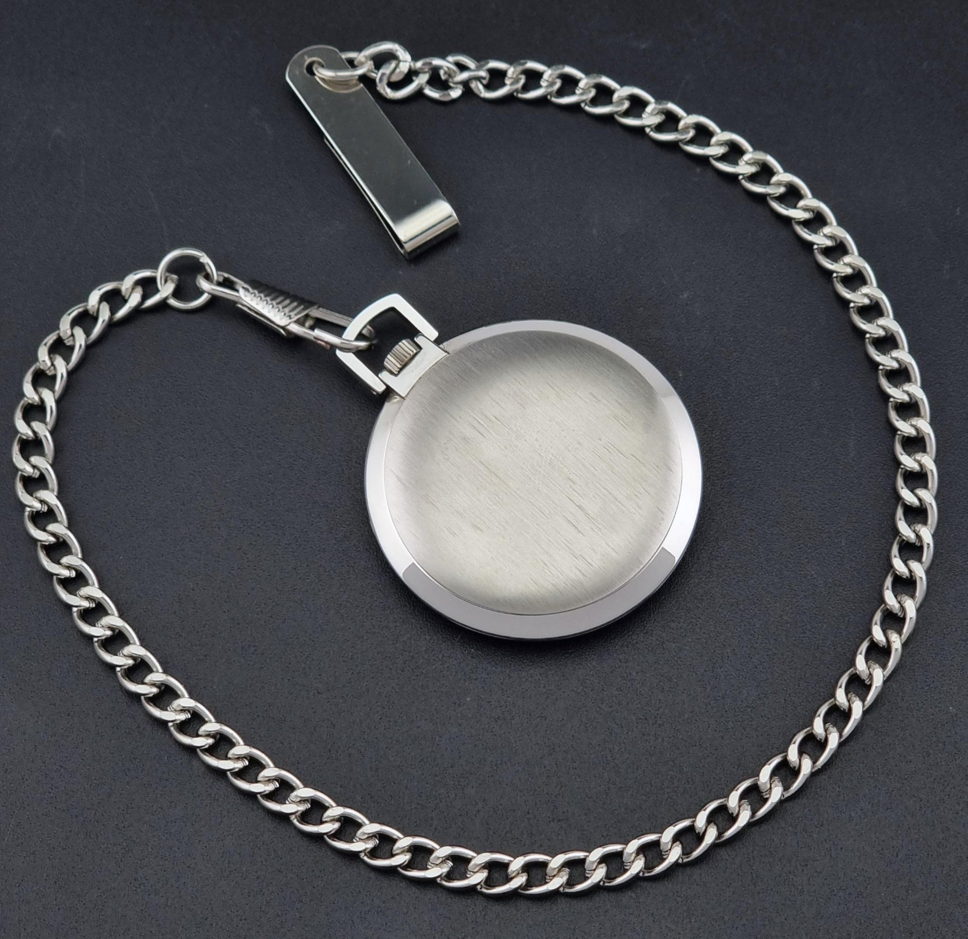 The back of a Universal Geneve 856105/01 silver-toned metal chain necklace with a round bezel pendant, displayed on a dark textured background.