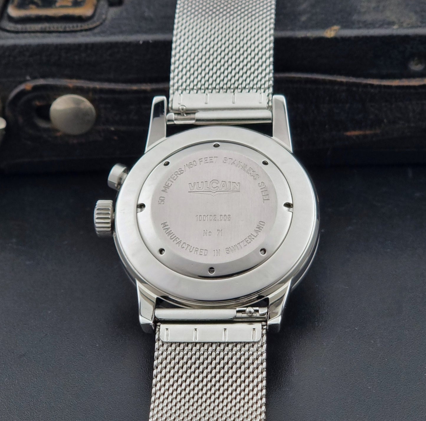 Vulcain Cricket Alarm watch 100102.008 with a blue face on a dark gray background case back view