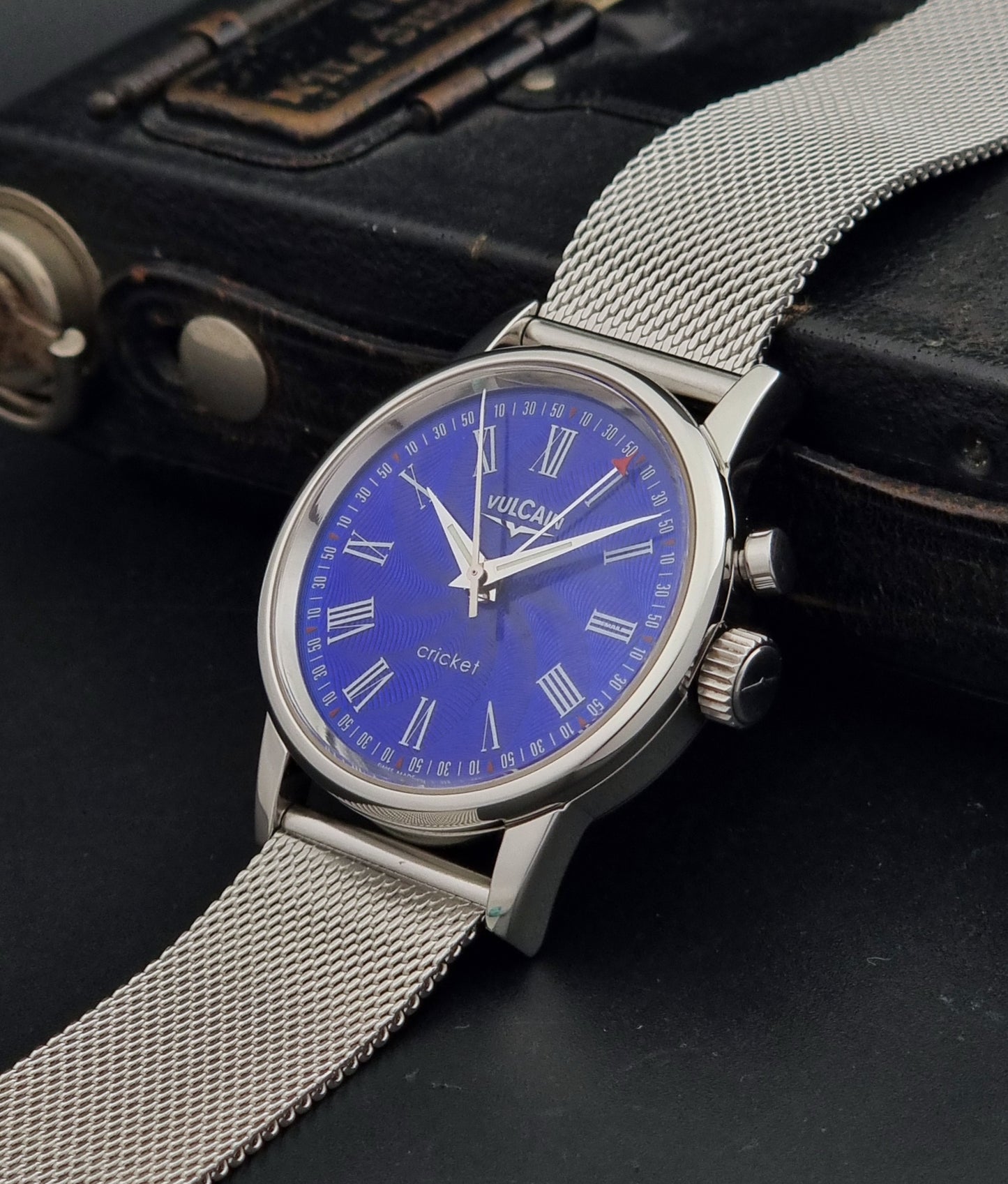 Vulcain Cricket Alarm watch 100102.008 with a blue face on a dark gray background crown profile view