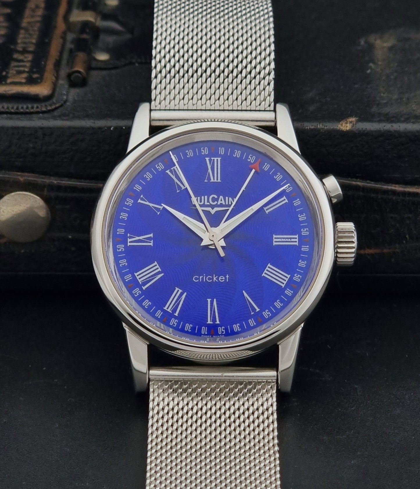 Vulcain Cricket Alarm watch 100102.008 with a blue face on a dark gray background dial view