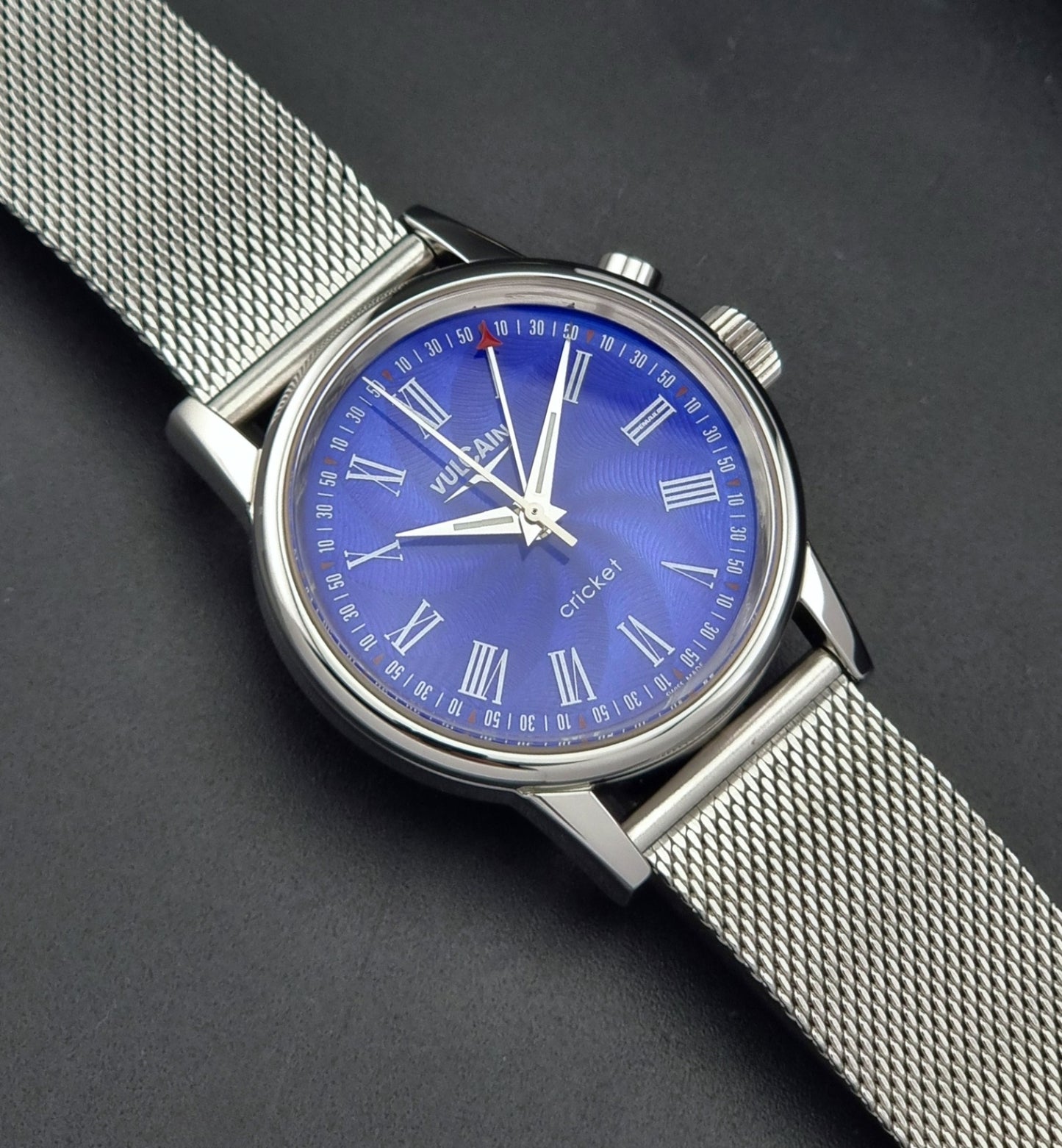 Vulcain Cricket Alarm watch 100102.008 with a blue face on a dark gray background close dial view
