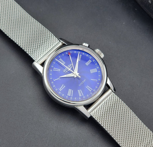 Vulcain Cricket Alarm watch 100102.008 with a blue face on a dark gray background dial