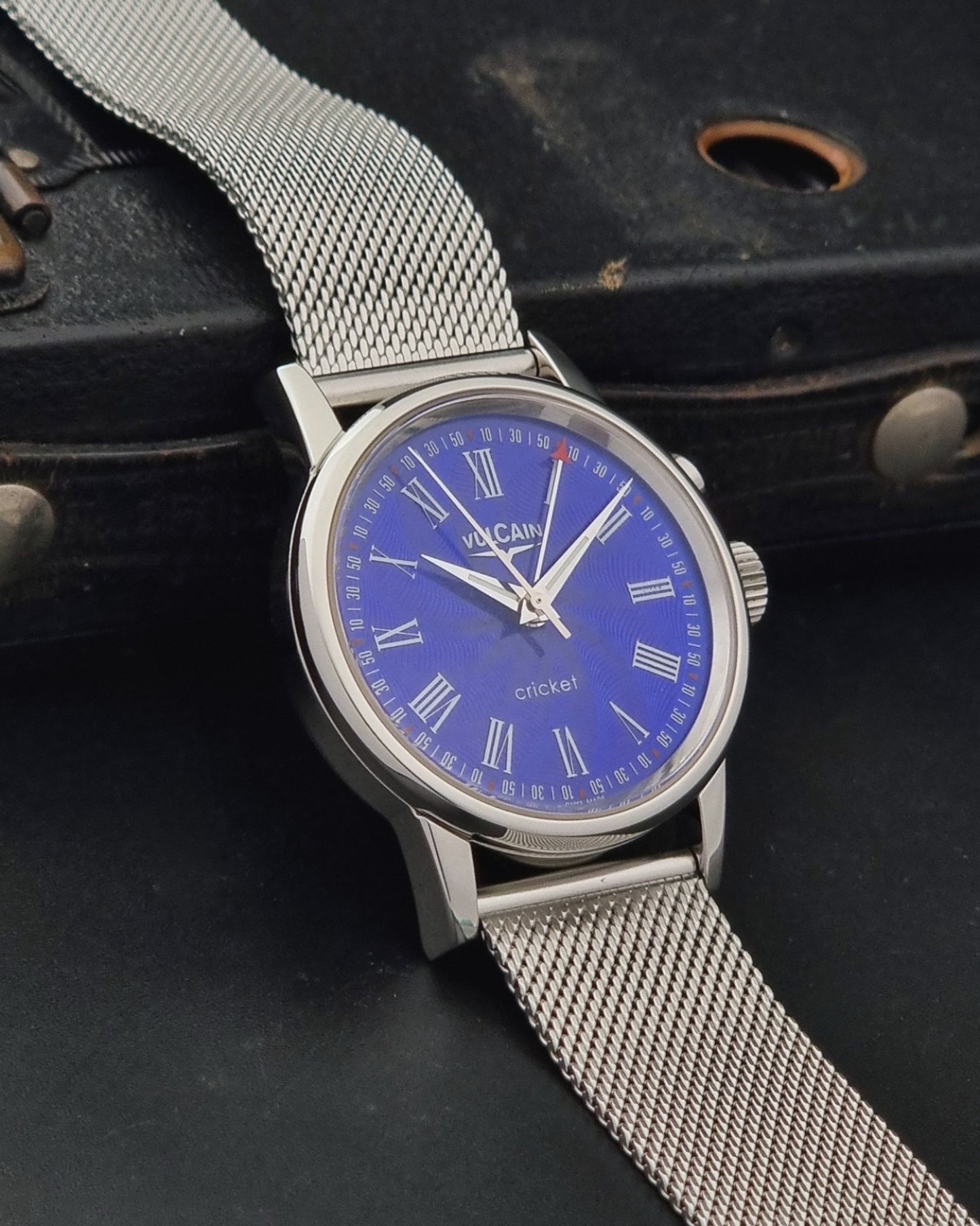 Vulcain Cricket Alarm watch 100102.008 with a blue face on a dark gray background side profile view