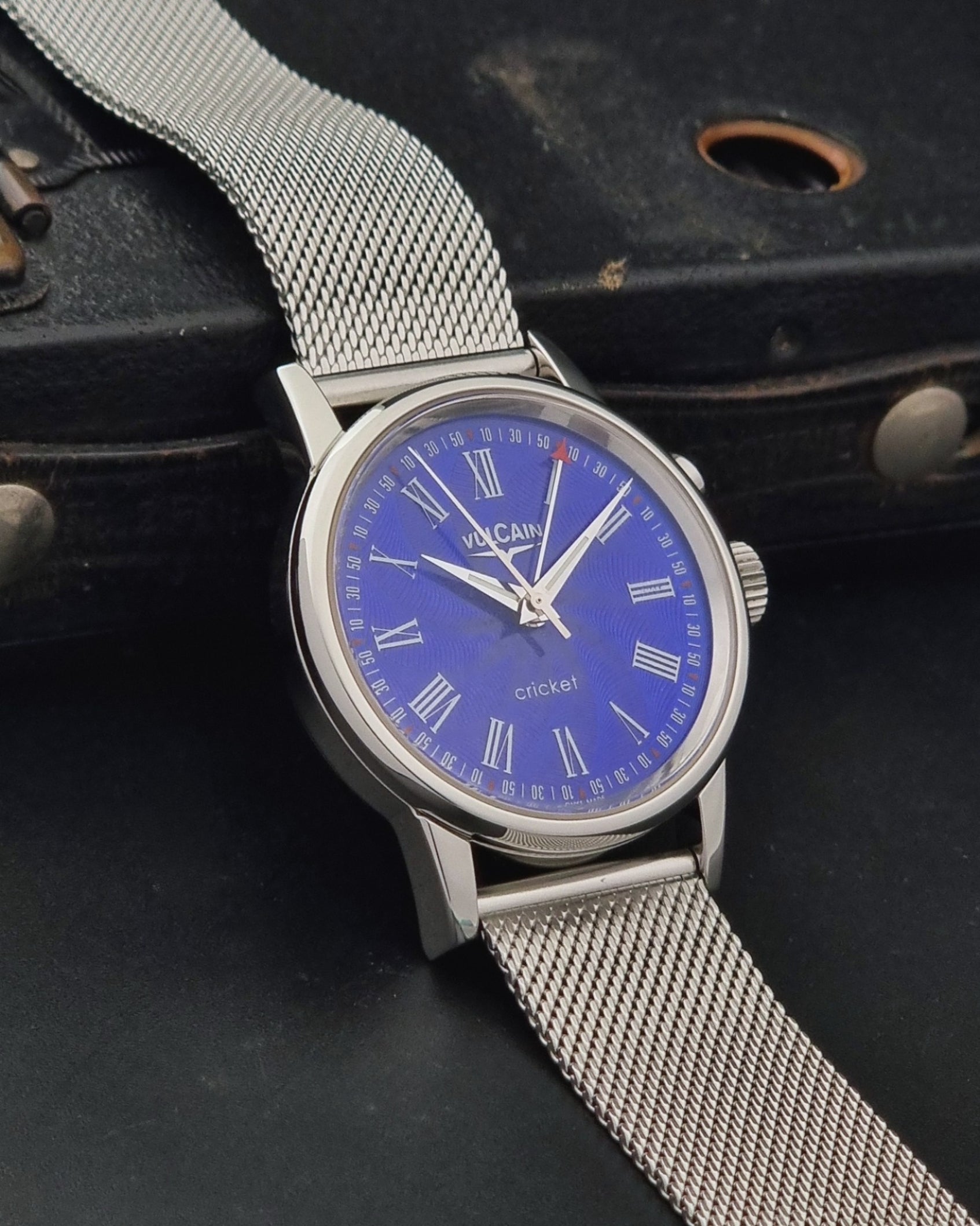 Vulcain Cricket Alarm watch 100102.008 with a blue face on a dark gray background side profile view