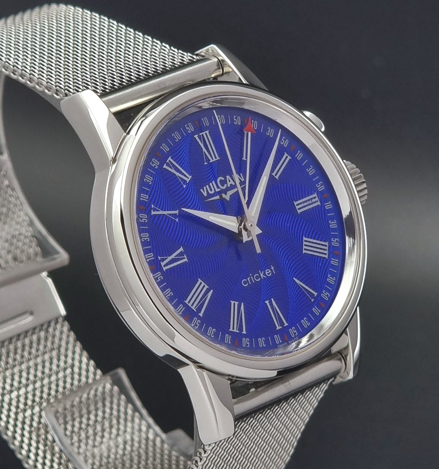 Vulcain Cricket Alarm watch 100102.008 with a blue face on a dark gray background side view