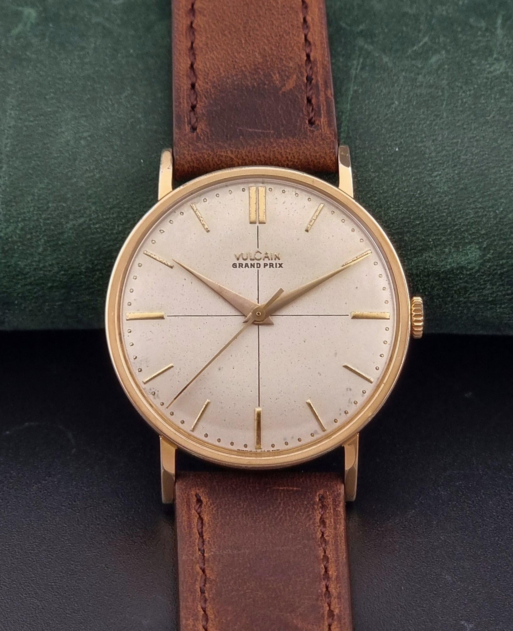Vintage Vulcain Grand Prix watch with brown leather strap and gold case on a dark surface front view