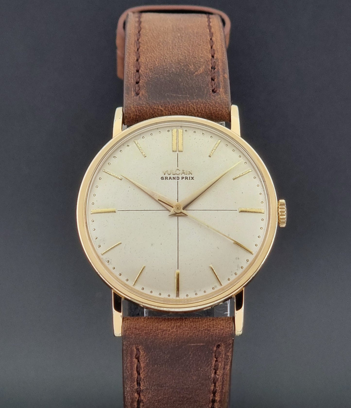 Vintage Vulcain Grand Prix watch with brown leather strap and gold case on a dark surface close dial view