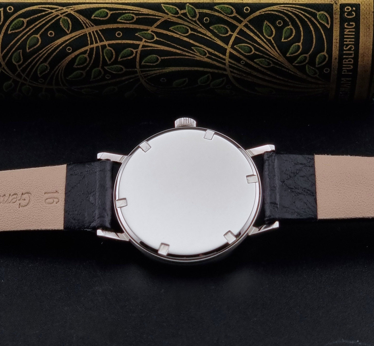 Vintage Unisex Zenith Wristwatch Manual wind with a black strap on a dark background case back view